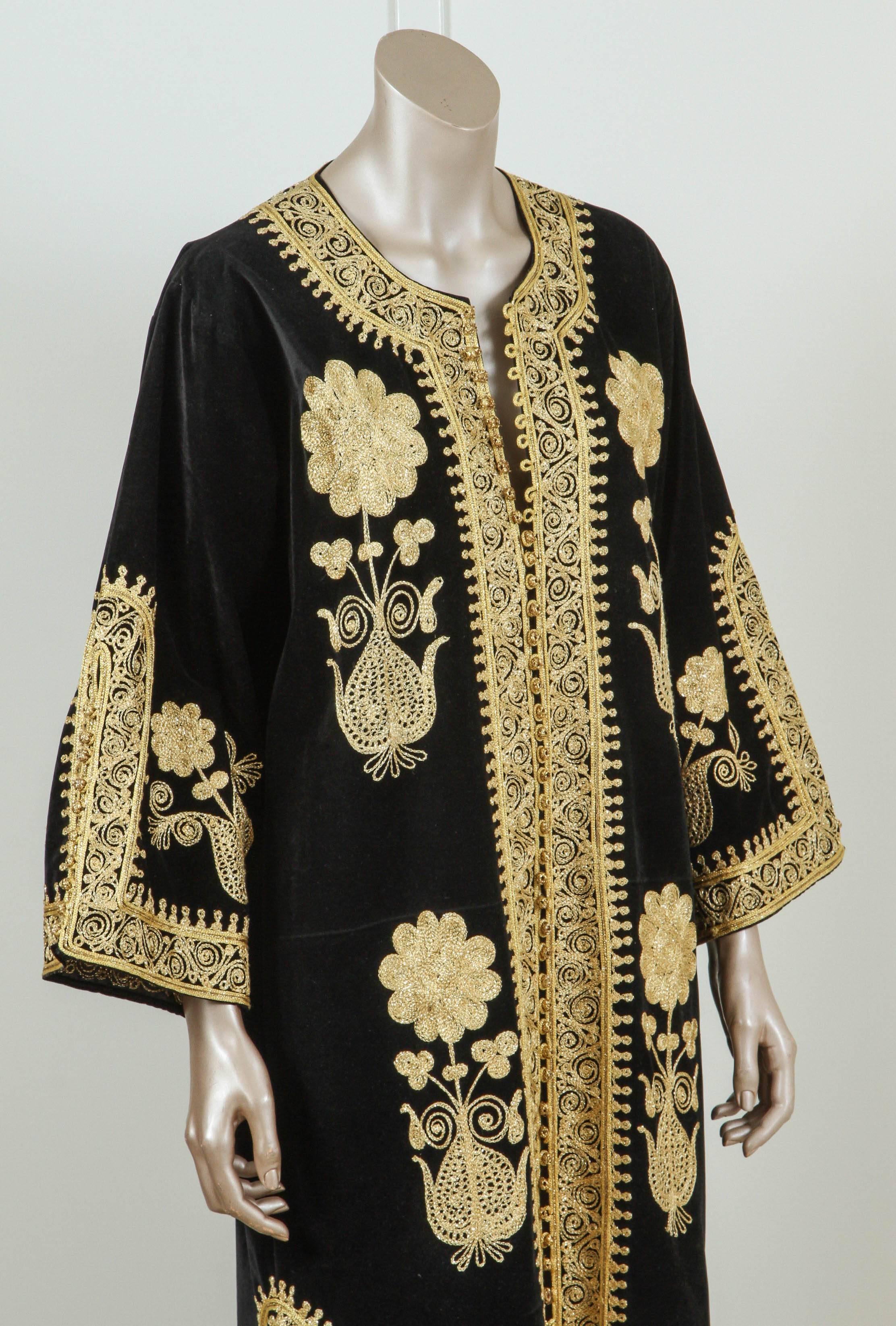 Elegant vintage designer Moroccan kaftan, black velvet embroidered with Turkish gold threads design all-over.
This black chic Gypsy Bohemian black velvet color maxi dress kaftan is embroidered and embellished with gold thread metallic designs and it
