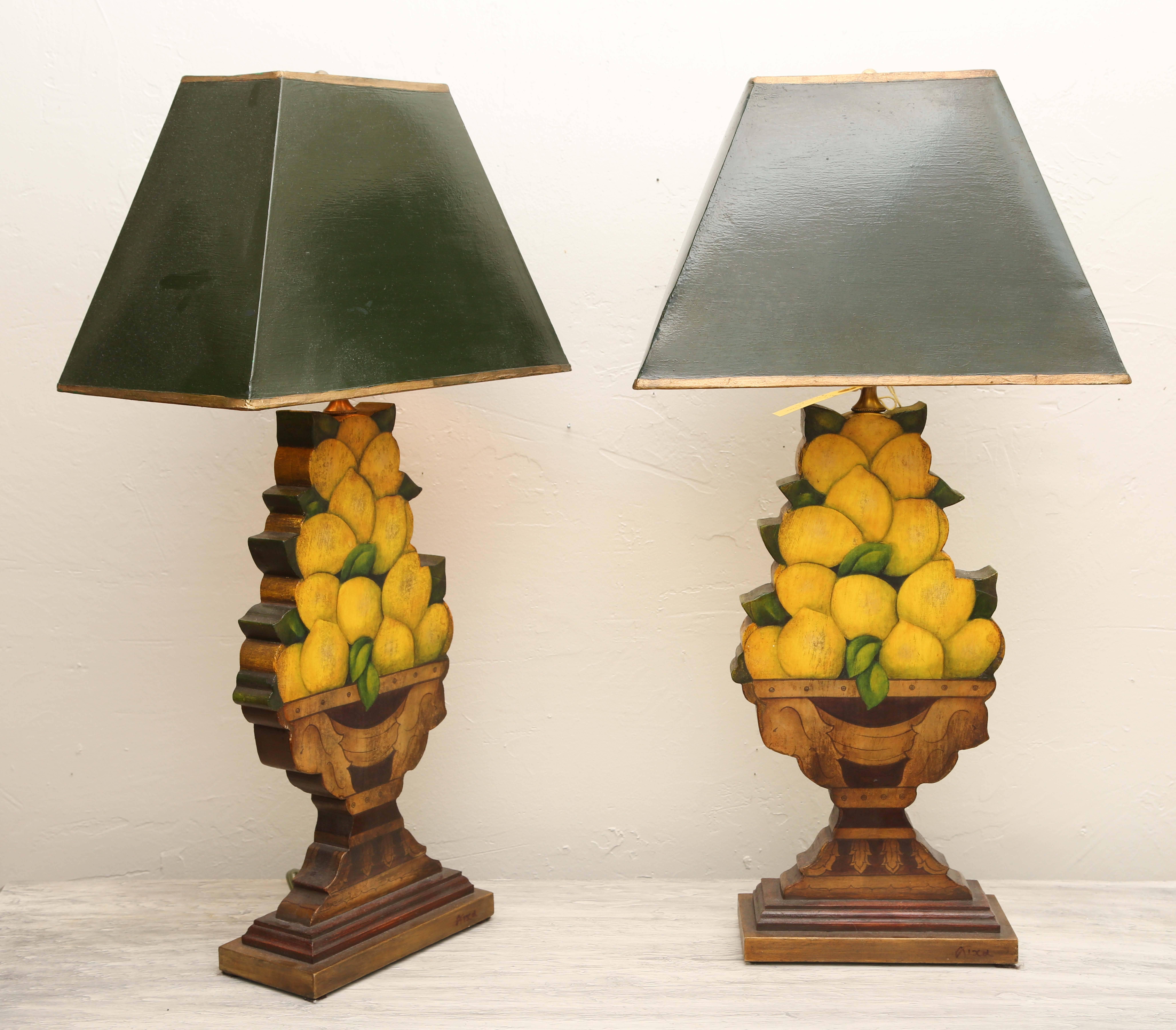 Elegant pair of lemon topiary lamps with an urn base and painted hunter green shade with gold trim.
