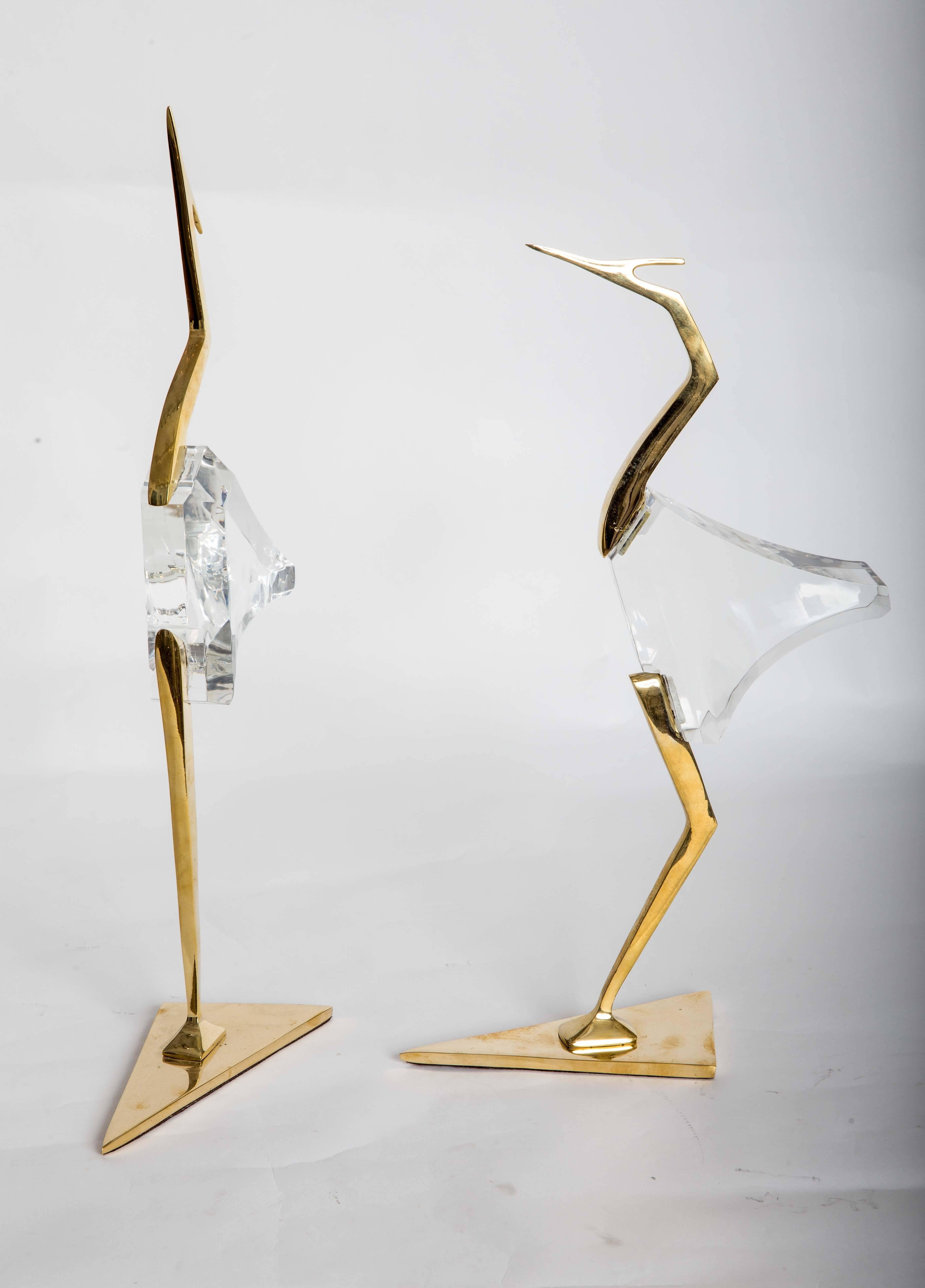 Pair of stylized Lucite and brass crane sculptures.