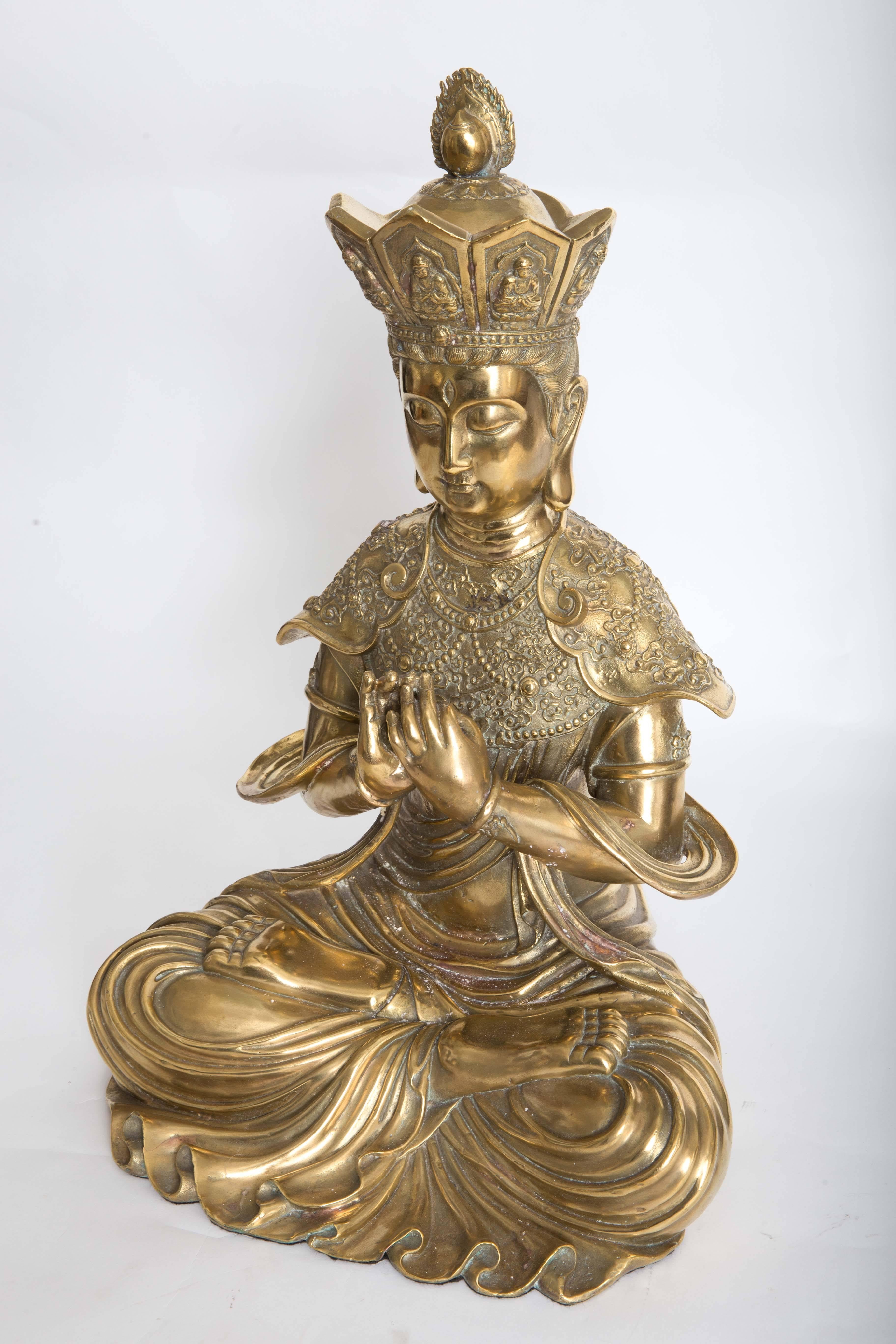 Intricately etched bronze sculpture of seated Diety figure.