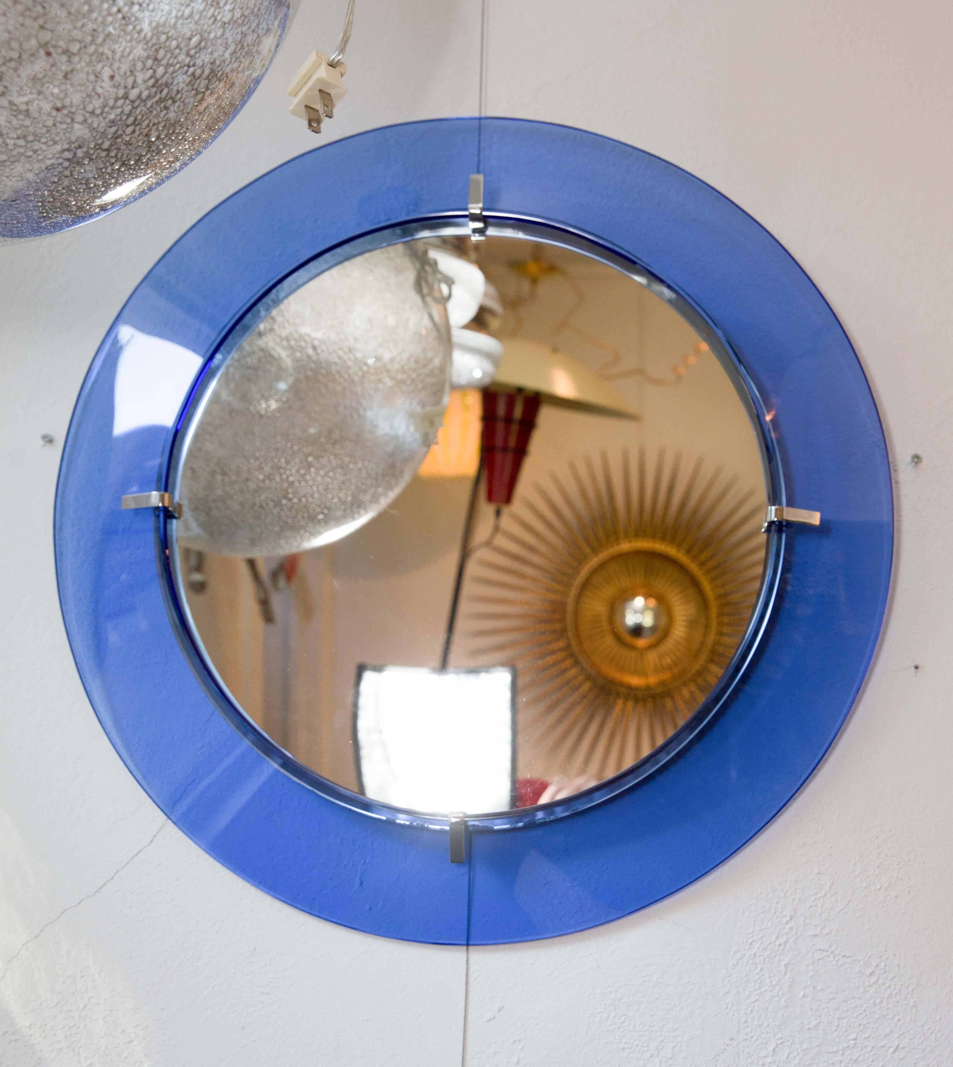 Circular mirror with floating blue glass surround with chrome detail.