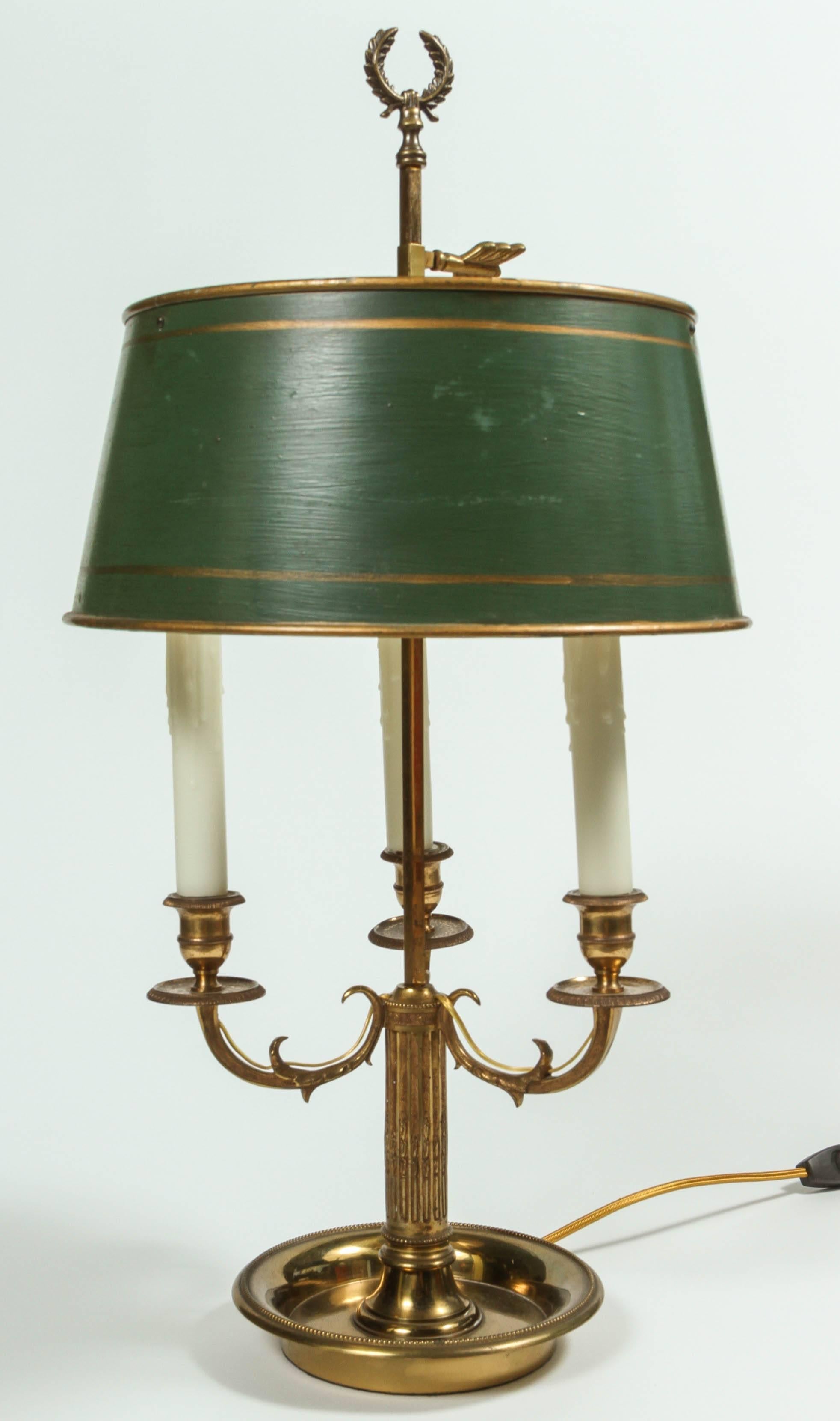 A Louis XVI style three-light brass bouillotte lamp fitted with an adjustable green tole shade with gilt detail, 20th century. Newly rewired with new candle sleeves.
  