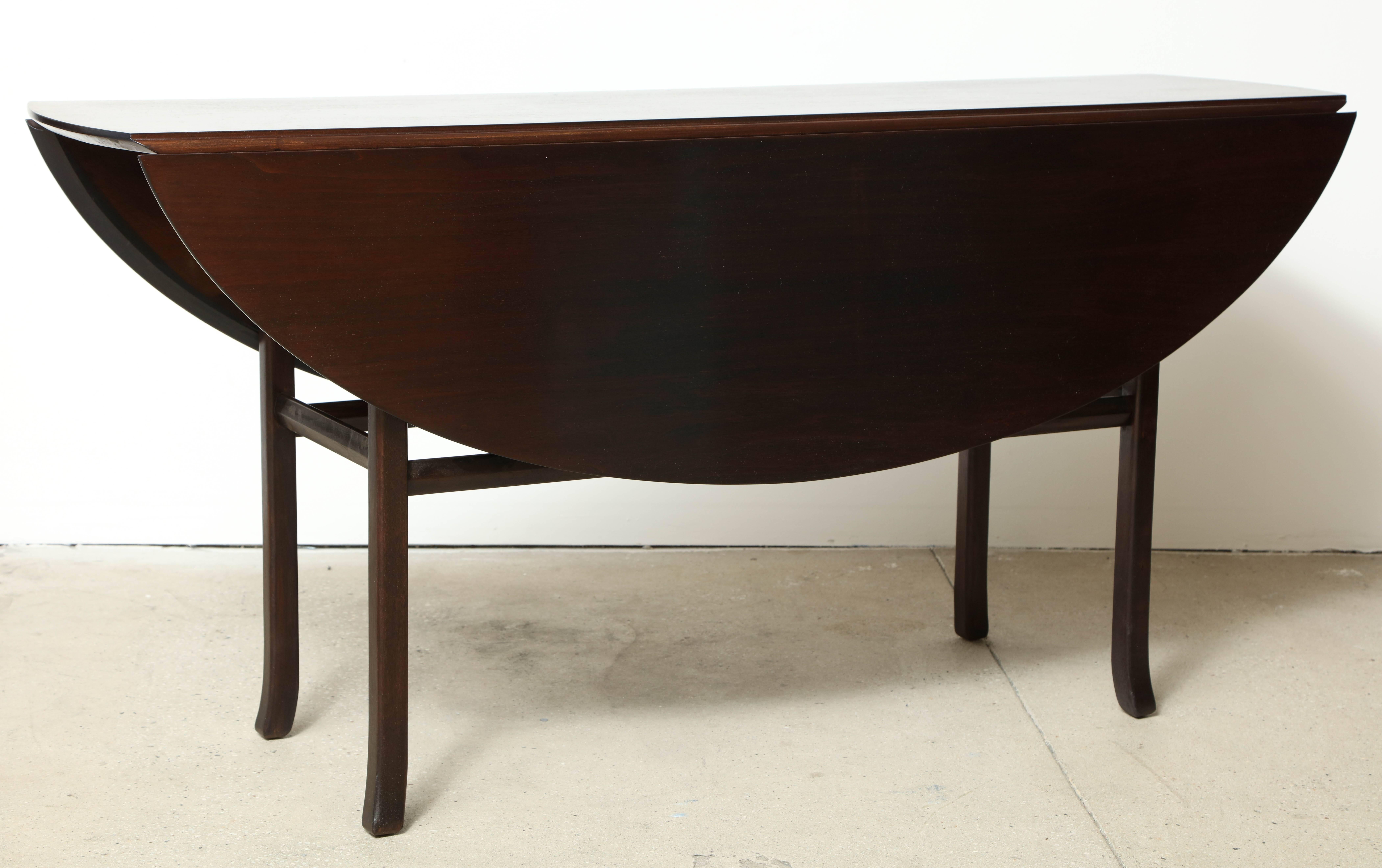 A walnut double drop-leaf console table by Kip Stewart, circa 1950, refinished.
Closed dimensions: 60" W x 17" D x 29-1/4" H.
Open dimensions: 60" W x 45" D x 29-1/4" H.