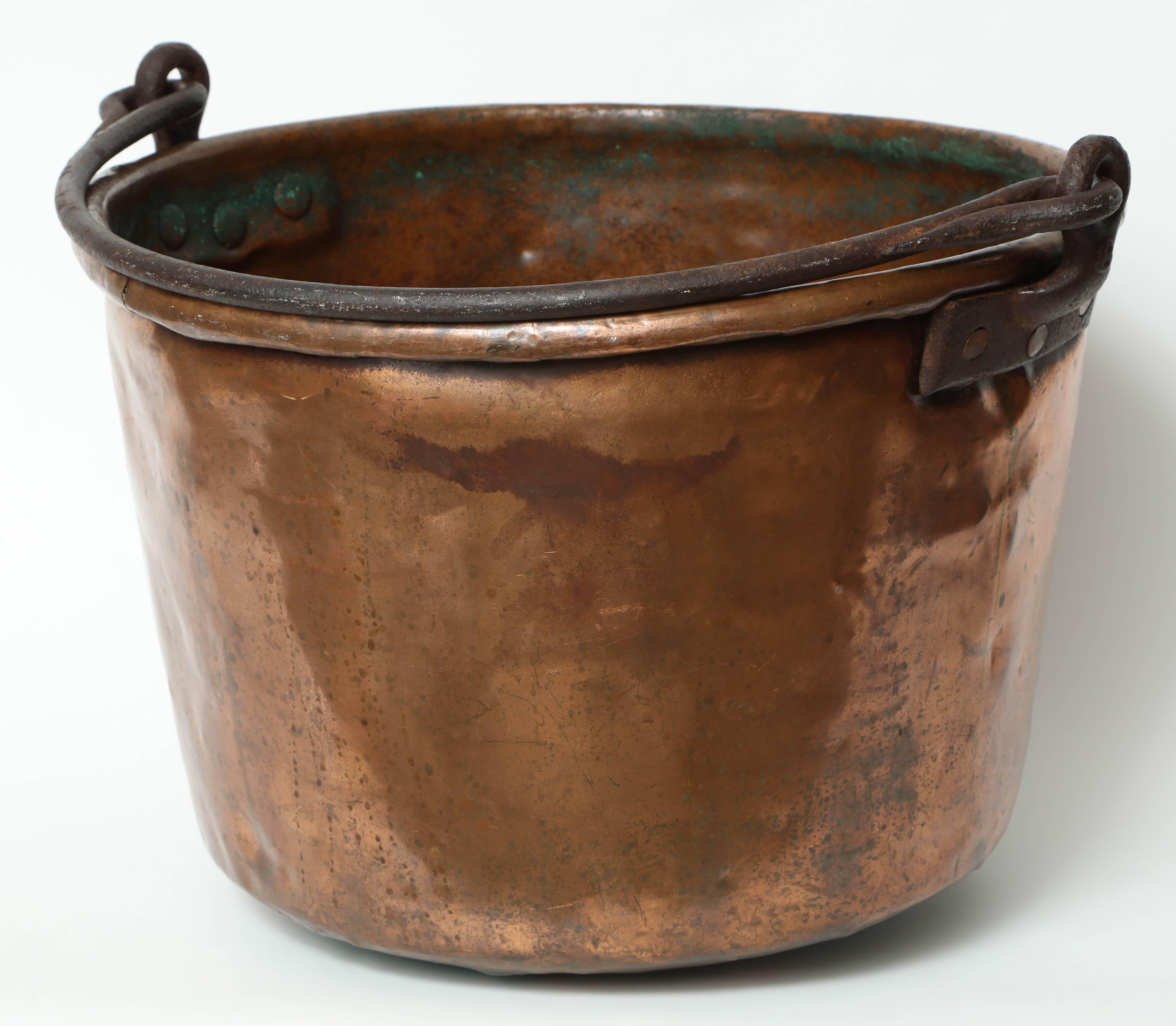 Impressive 19th century large copper vessel with a hand forged iron handle. Cauldron has a great warm patina and would be great as a large cache pot or firewood holder.