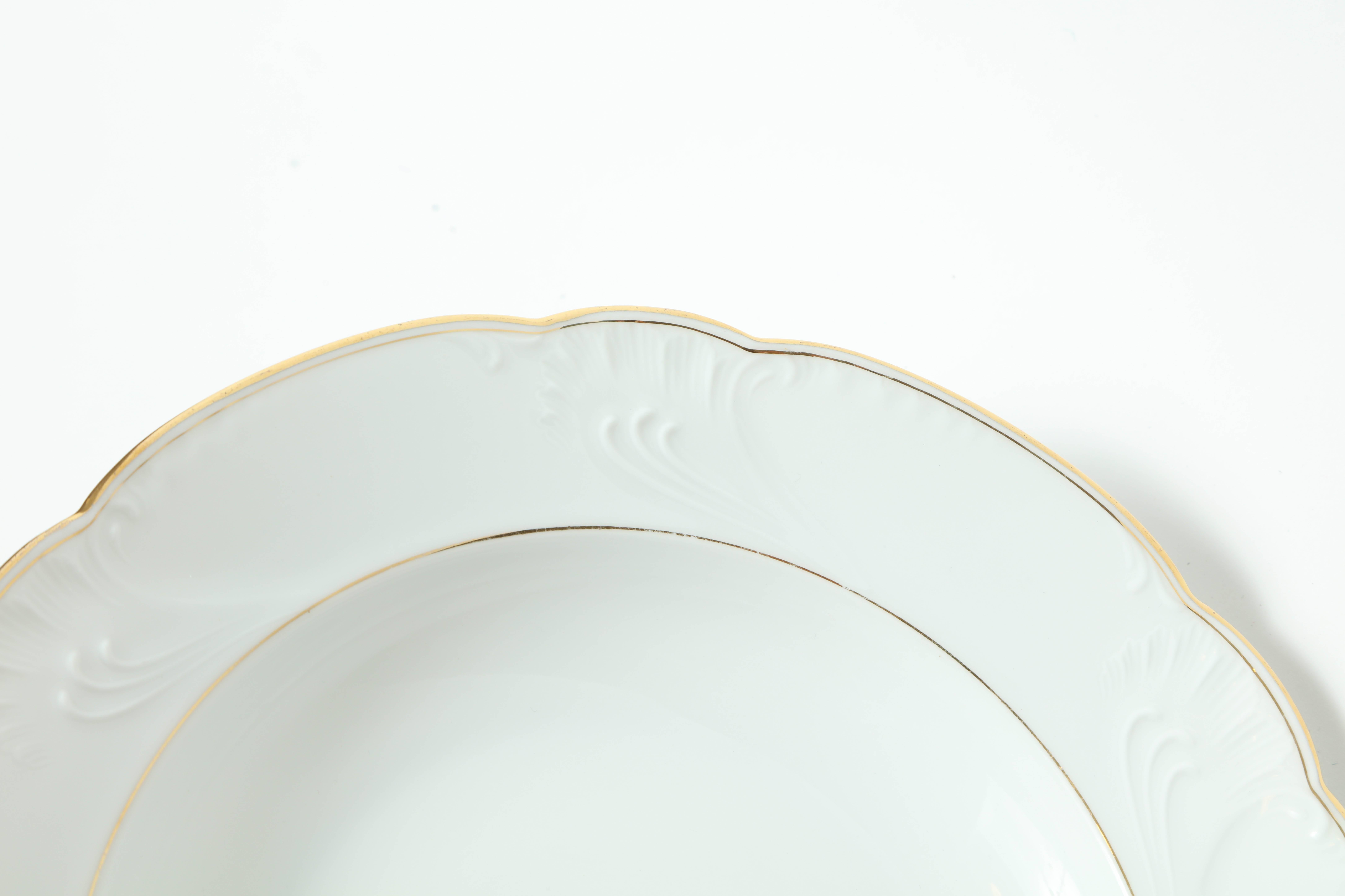 Set of eight porcelain rimmed soup bowls with a scalloped edge and gilt borders.
Marked Praddatz & Co, Berlin on underside.