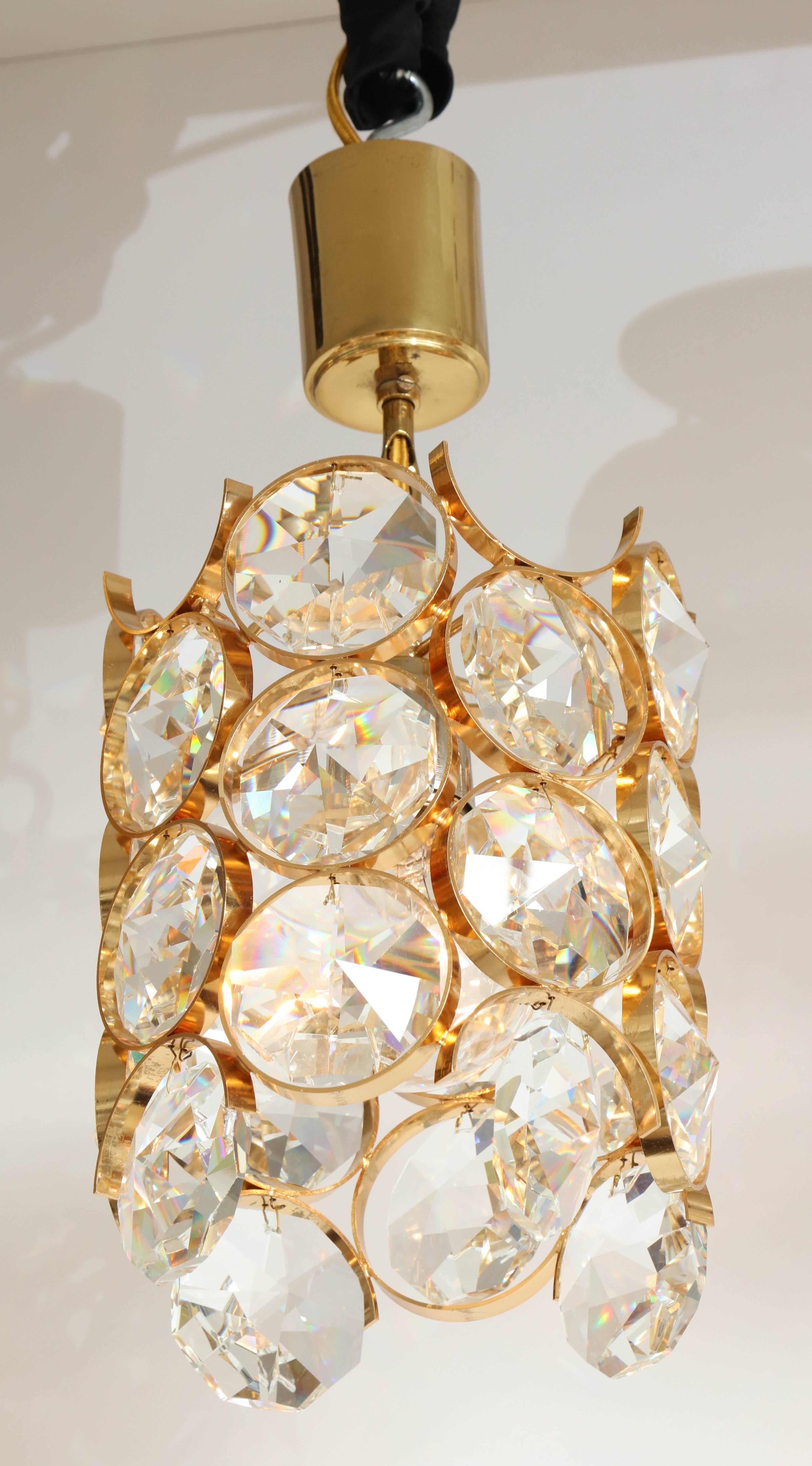 Striking pendant chandelier with large faceted crystal prisms suspended on a 22-karat gilt brass frame. Rewired for use in the USA, uses one standard bulb.