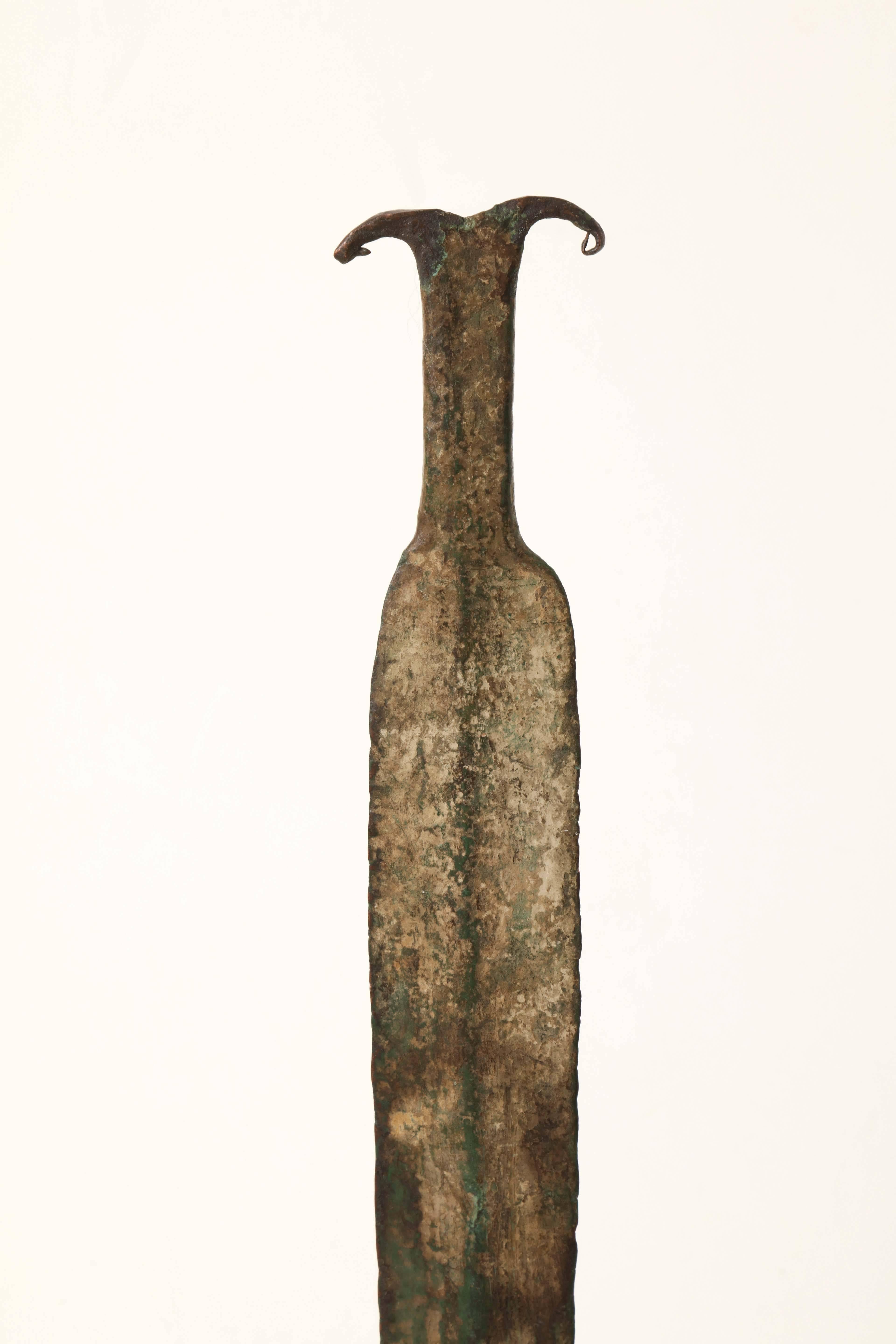 An ancient bronze sword, first millennium BC, mounted on a contemporary stand.
