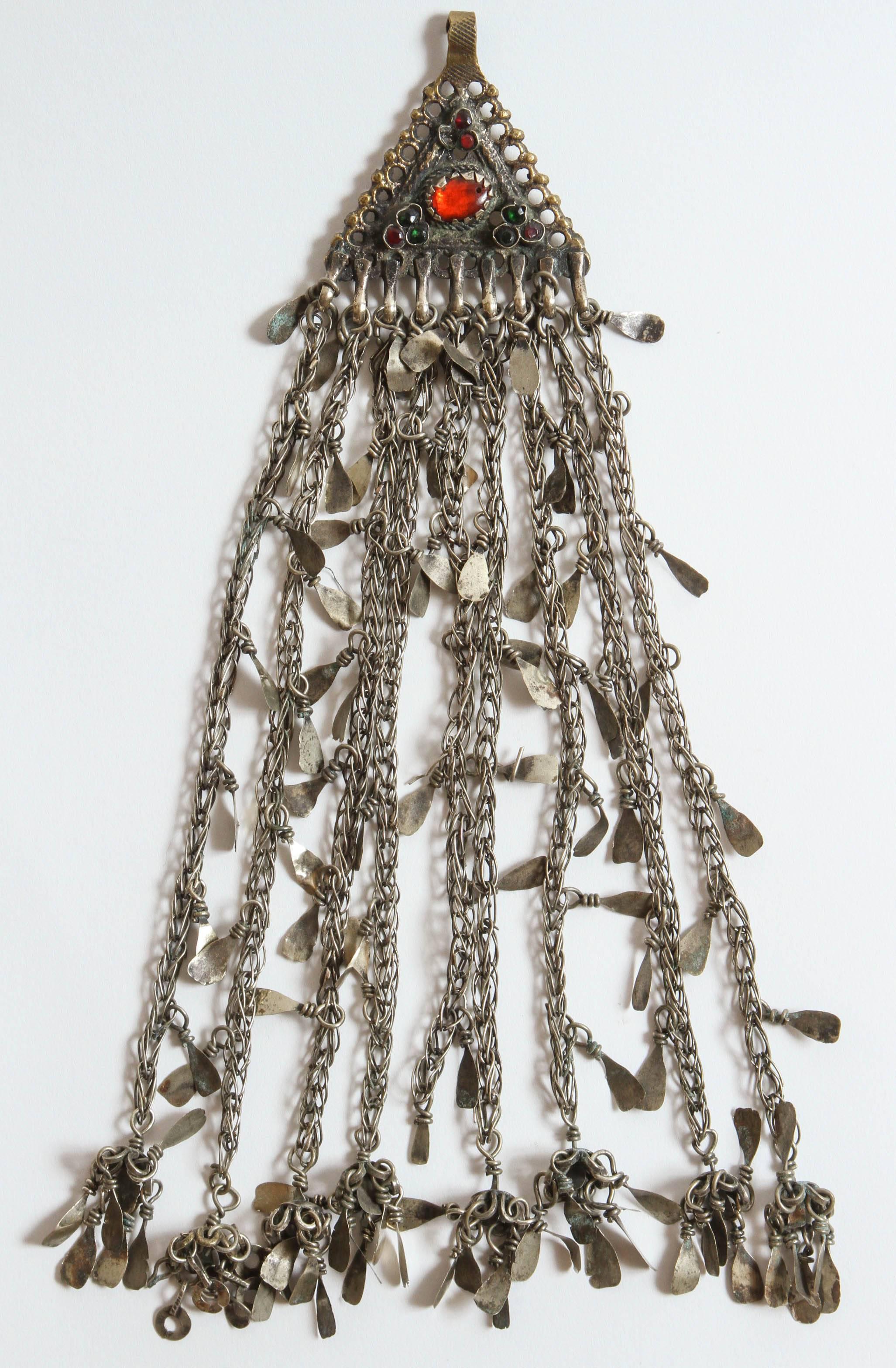 Handgefertigt in Kaschmir vom Nomadenstamm der Kuchi in Zentralasien. Der große, dreieckige Silberanhänger ist ein traditionelles Motiv in Kaschmir. Der obere Teil hat den traditionellen Haken zum Befestigen am Haar oder einer anderen Kopfbedeckung.