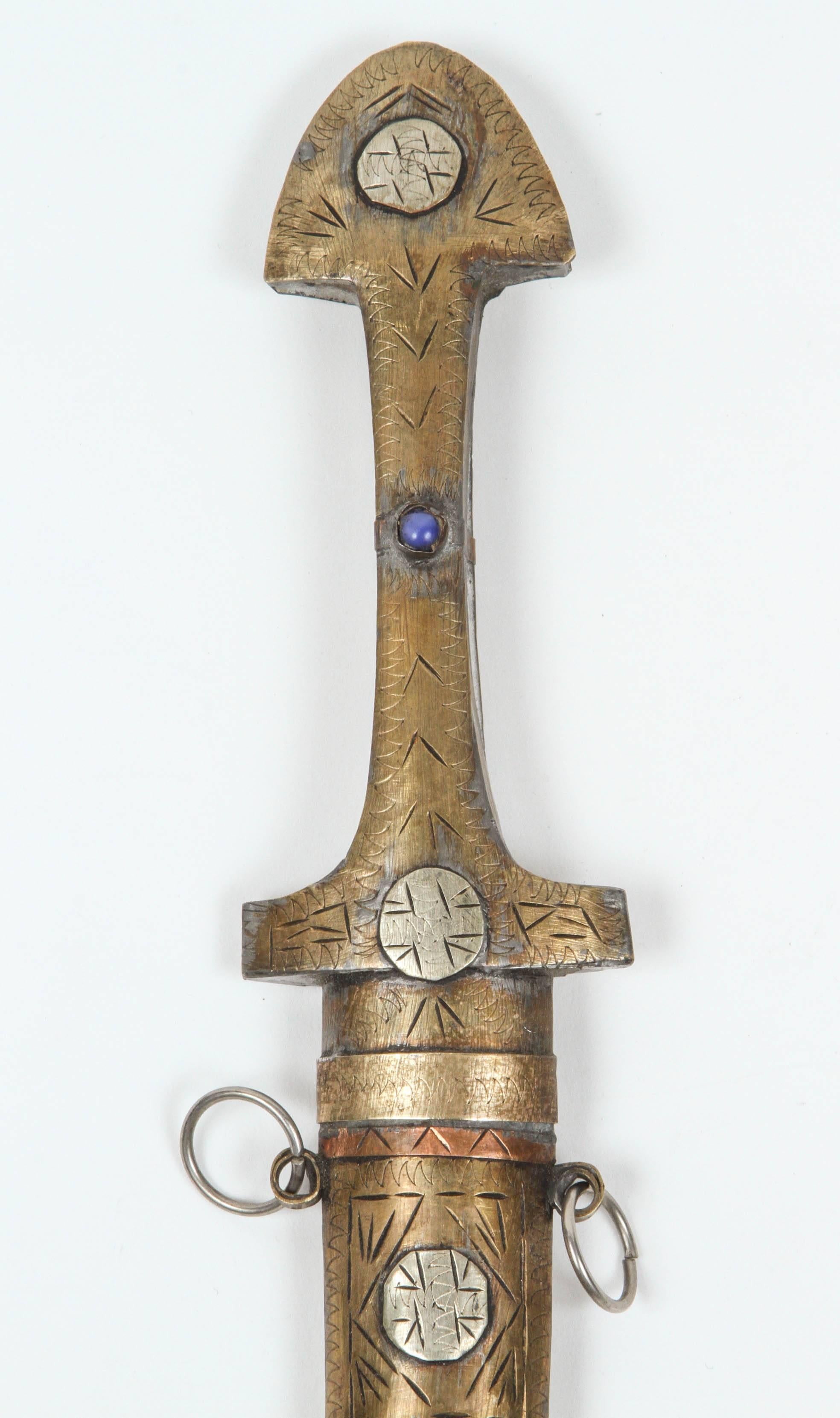 Handcrafted Moroccan brass dagger, mixed metal, copper, nickel and enamel.
Moroccan Hand carved Khoumiya dagger, of typical shape with curved blade, with brass fittings, complete with scabbard with tribal Berber motifs. 
Hand-crafted by artisans in