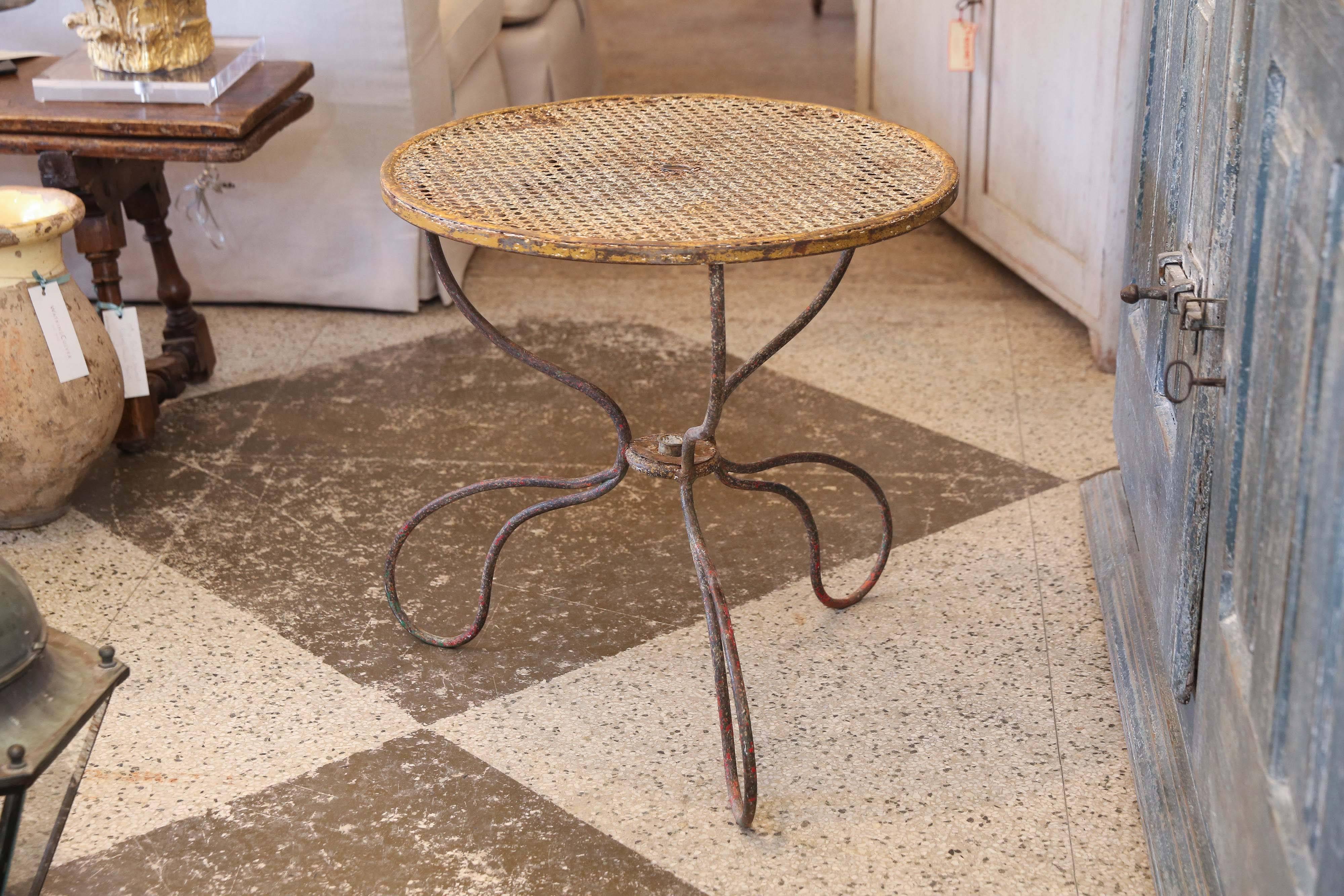 French garden table with metal caned woven top. Unusual, elegant shaped iron base, wonderful original patina.