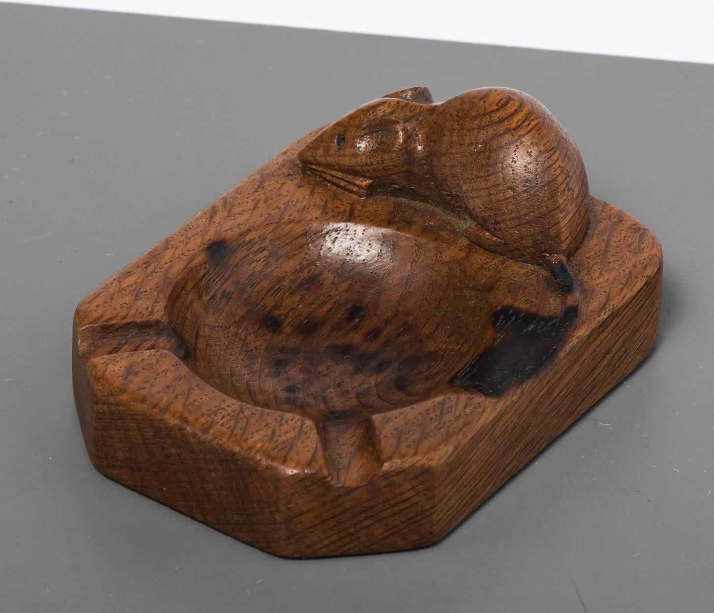 A Robert Mouseman Thompson oak ashtray.
Carved mouse signature.
England, circa 1970.
Measures: 2 cm high x 10 cm wide x 7.5 cm deep.
 