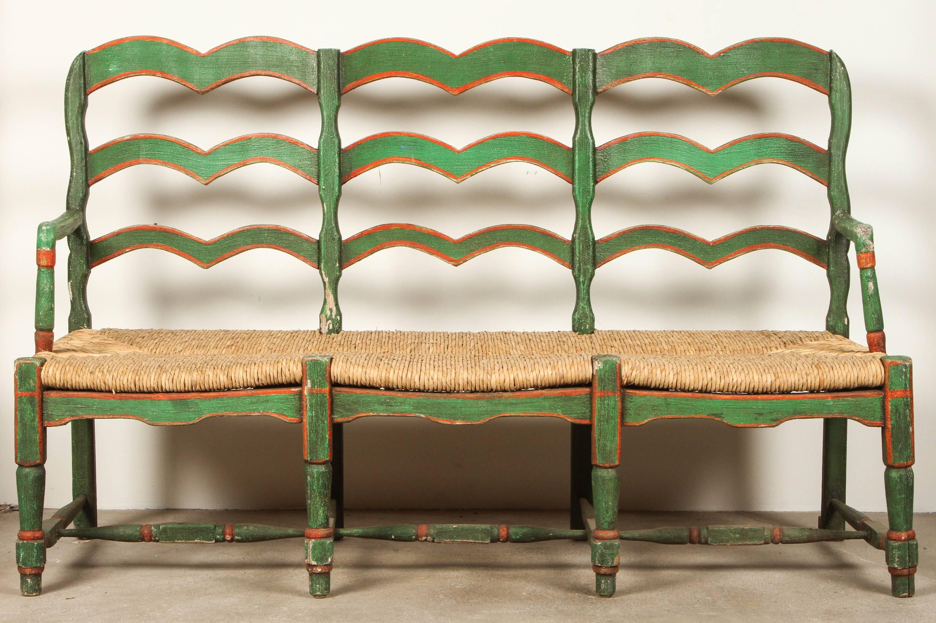 Green and red painted mexican bench with rush seat.