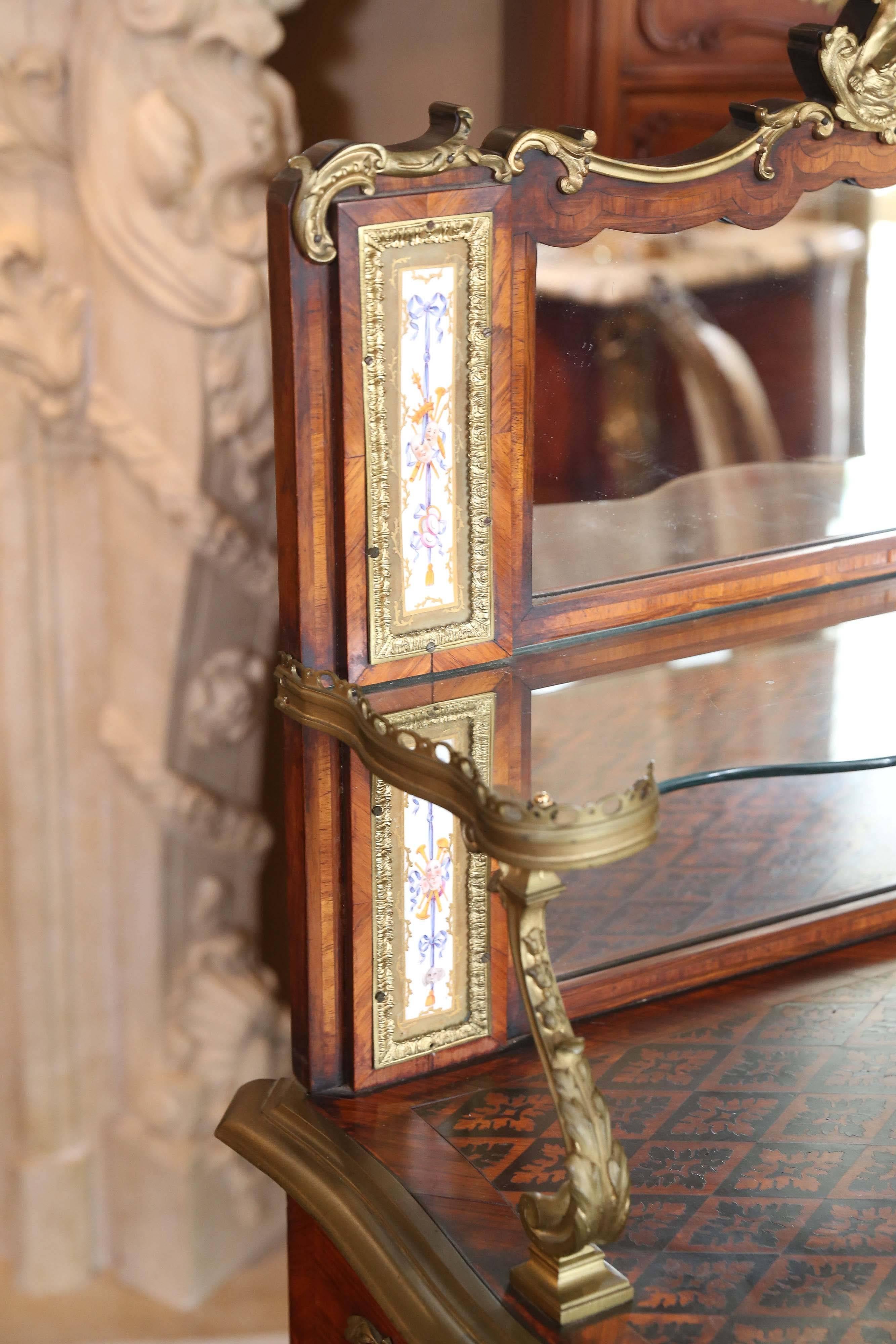 Exceptional French vanity table with gilt bronze mounts and inlaid porcelain plates in the Sevres style having a ground of celeste blue.
Painted with a floral motif. The mirrored back splash cresting in a bronze
doré design of two putties.