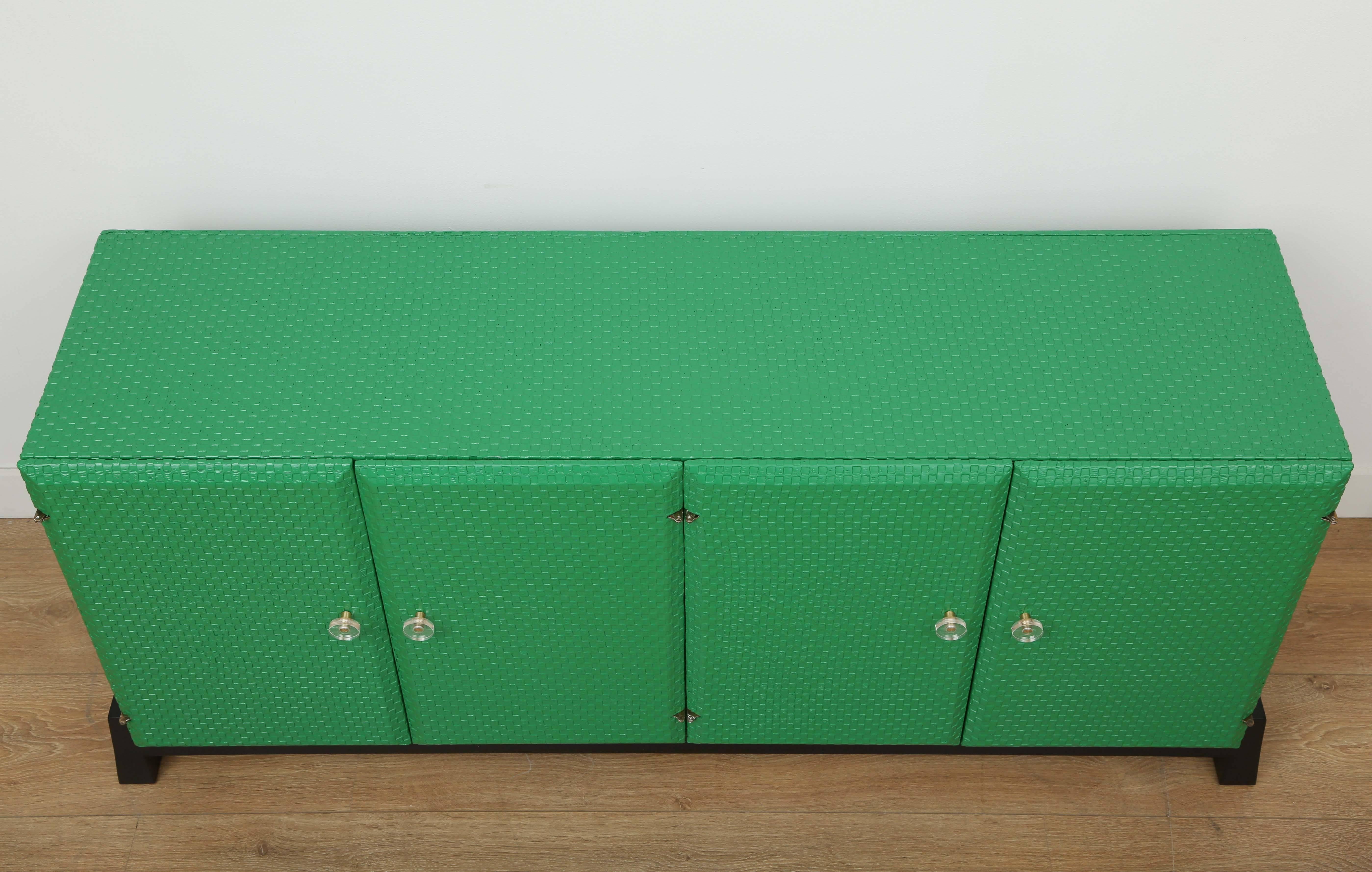1970s cabinet emerald green wrapped around grass cloth with black ebonised base and interior. 