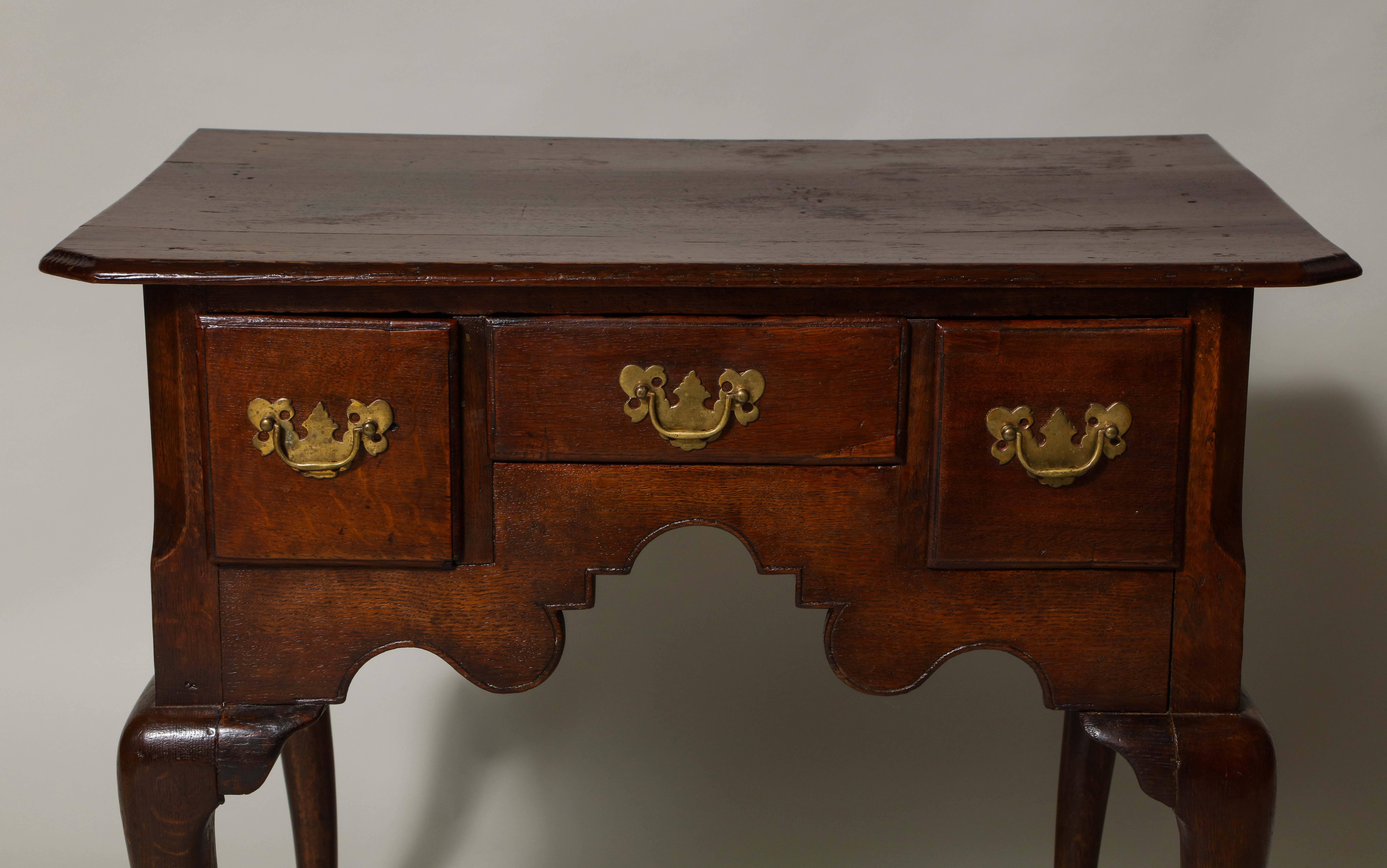 Good George II oak lowboy/dressing table, the molded with canted corners over three drawers over richly scalloped and beaded apron, the four cabriole legs deeply chamfered at the carcass and with shaped brackets, the whole with pleasing, mellow