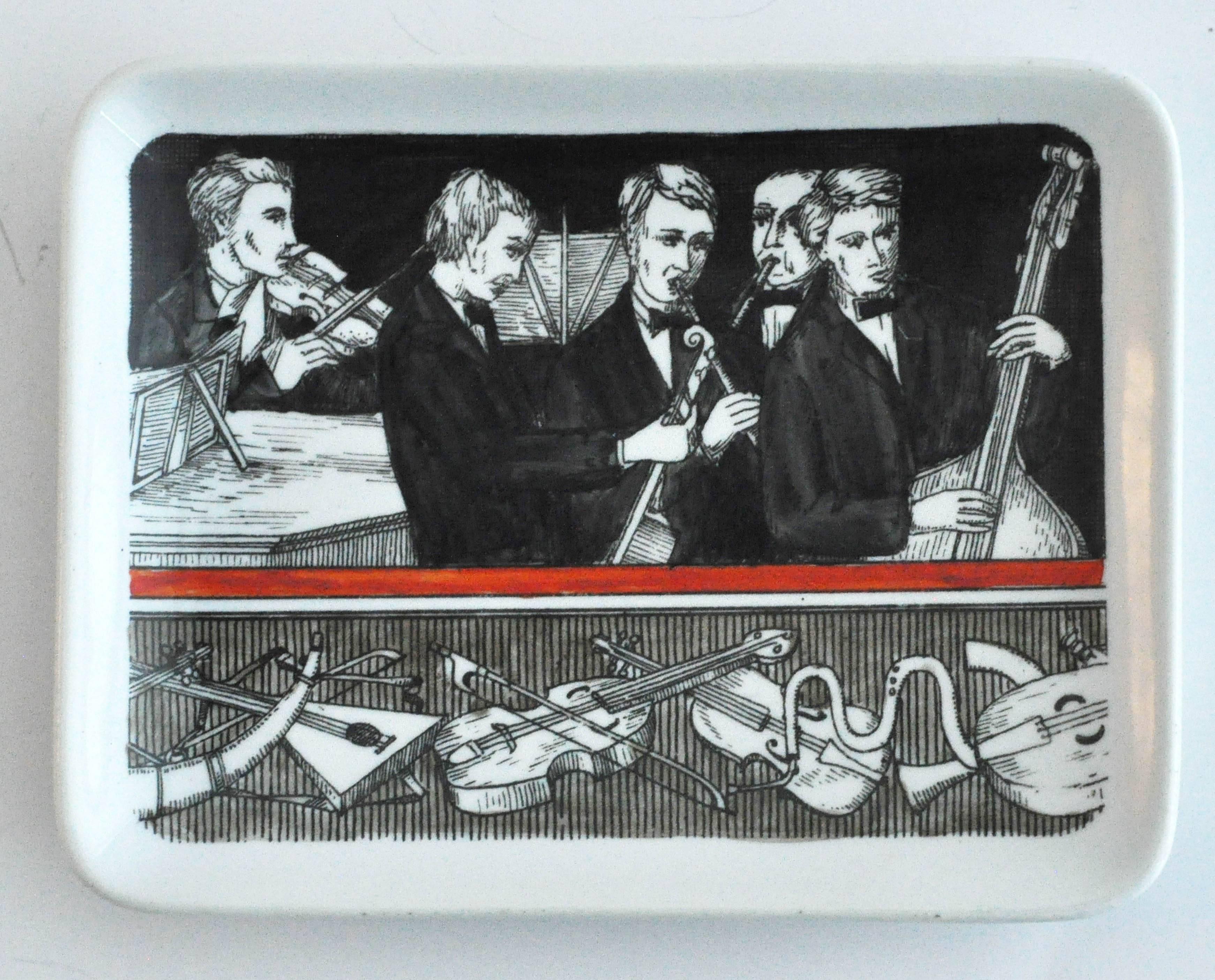 A vintage ceramic pin dish by Piero Fornasetti for Rosenfeld Imports, depicting musicians and their instruments. Comprised of two horizontal decorative panels, the design recalls the visual style of ancient Greek pottery, one of Fornasetti's many