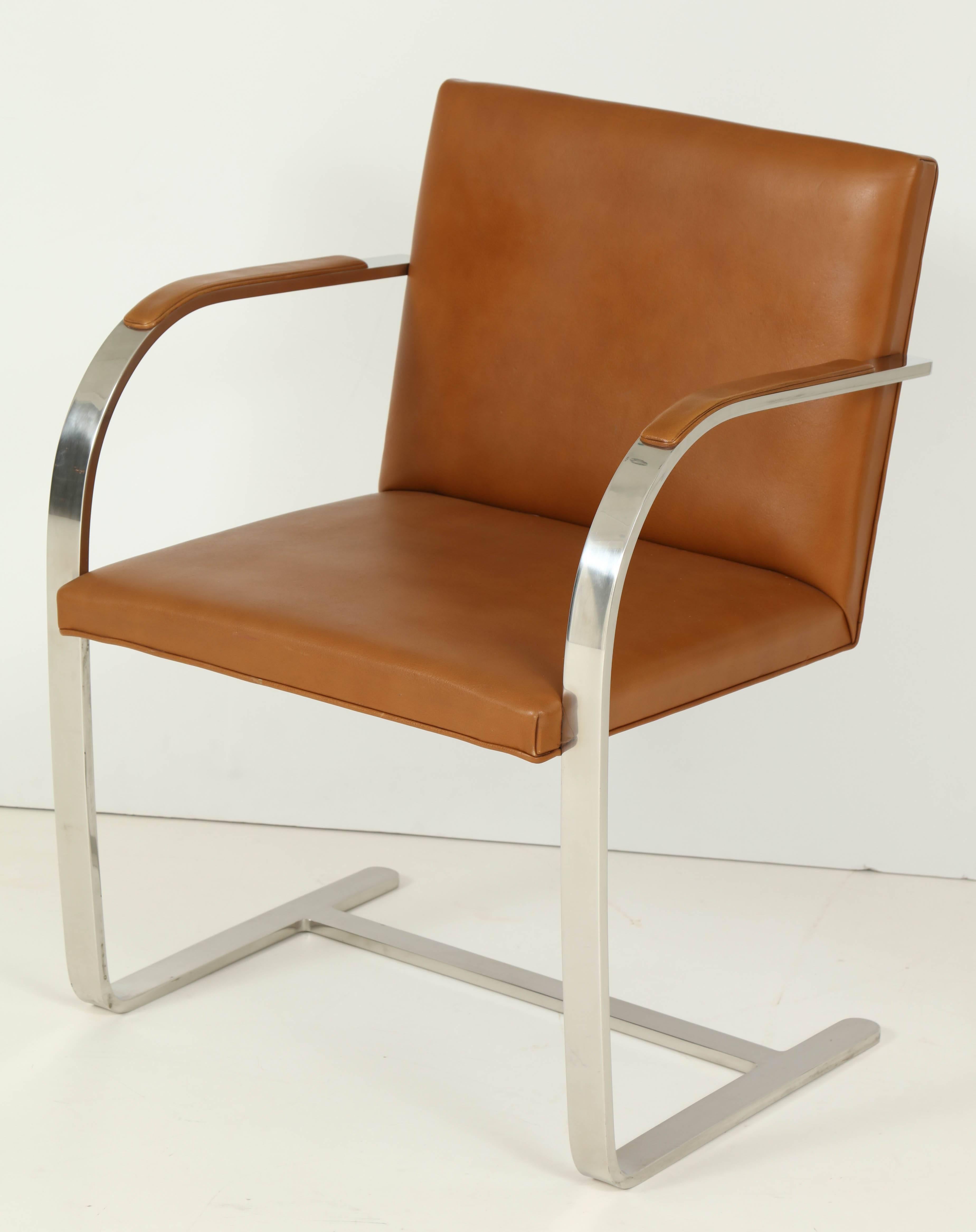 Ludwig Mies van der Rohe's flat bar Brno Chair is comprised of polished chrome-plated steel and leather, made circa 1960s by Knoll. These chairs retain their original brown leather upholstery and arm pads as well as one of it's original Knoll