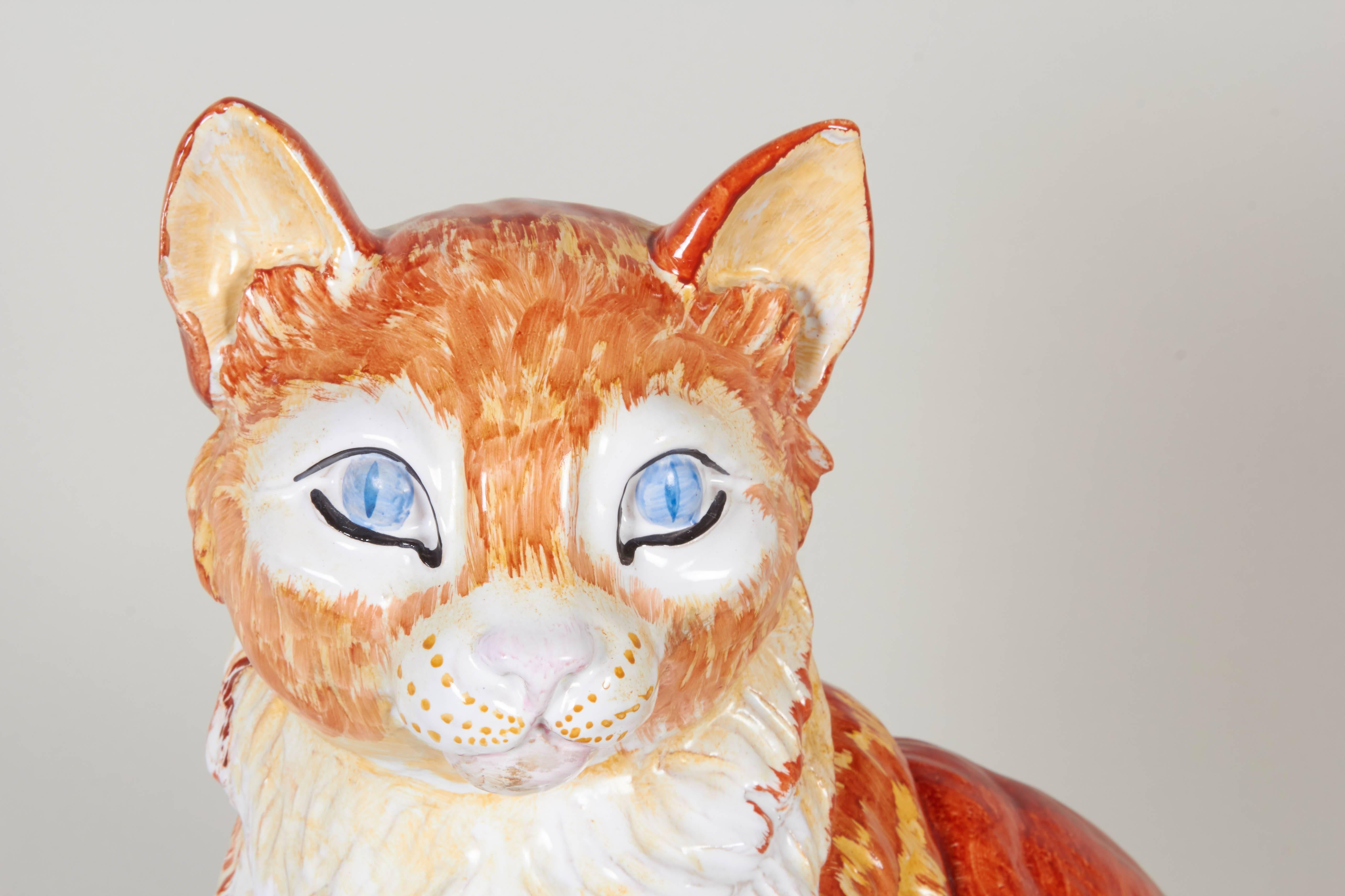 A hand-painted and glazed ceramic sculpture depicting an orange stripped tabby cat, produced in Italy, circa 1970s for Meiselman Imports. Markings include serial #K345 and [Made in Italy for Meiselman Imports] written to the bottom, in addition to