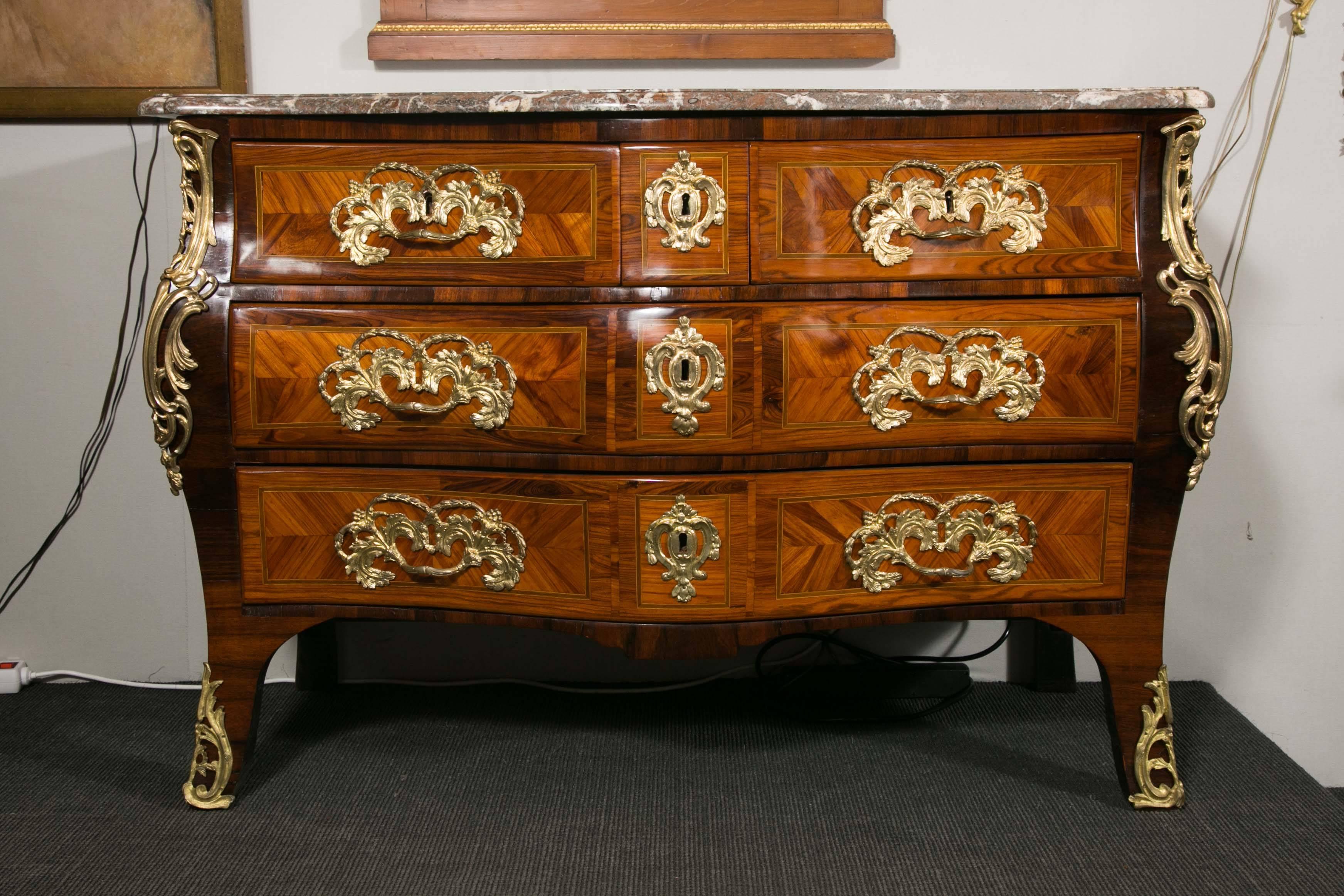 Elegant 18th century commode in marquetry and rare inlaid woods with original bronze mounts. Louis XV period. Stamped 
