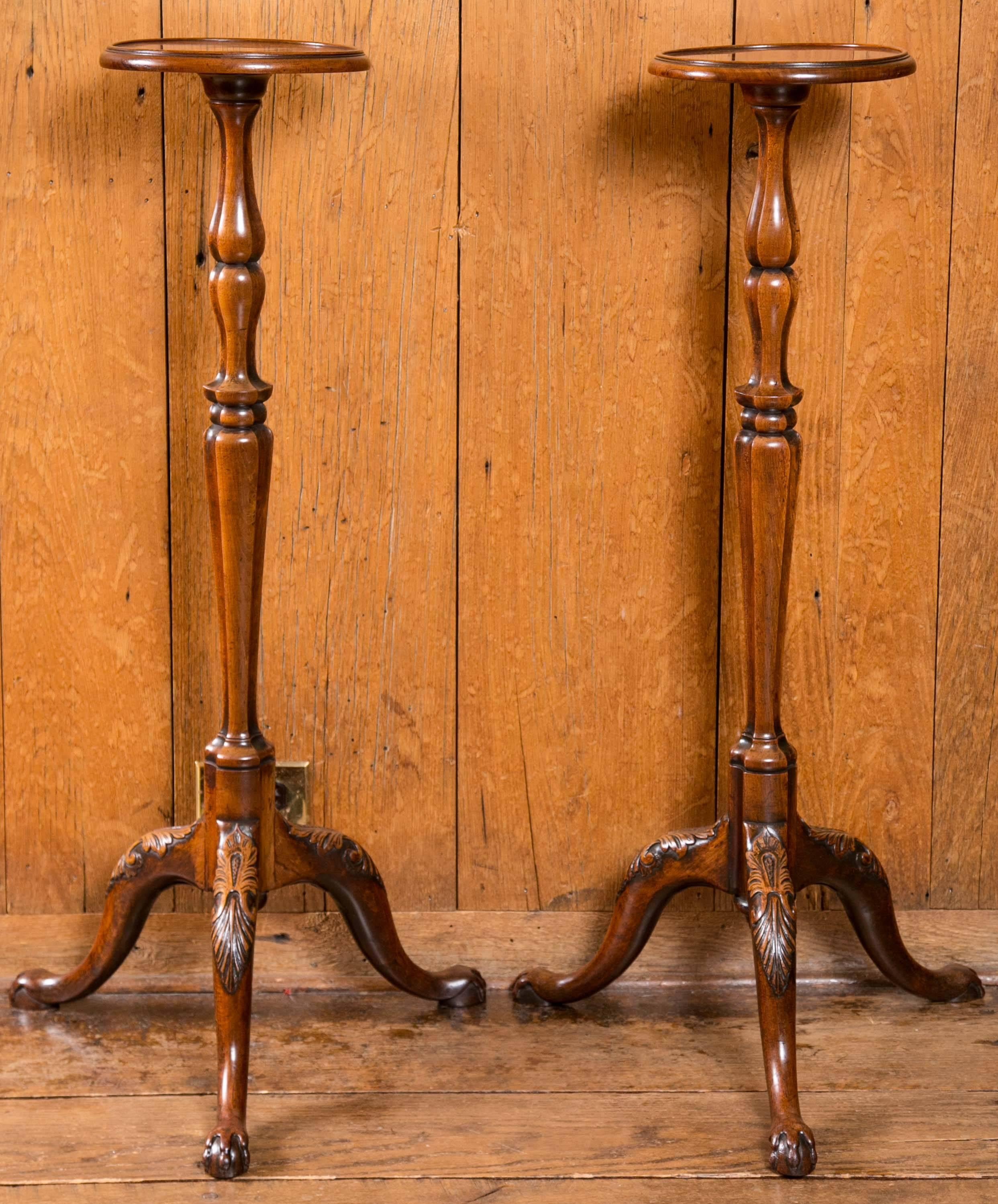 Fine pair of matching Regency candle stands with subtle lipped trays on top of unusually turned columns. Stands end with delicately carved cabriole legs with acanthus leaves on the knees and ending with ball and claw feet.