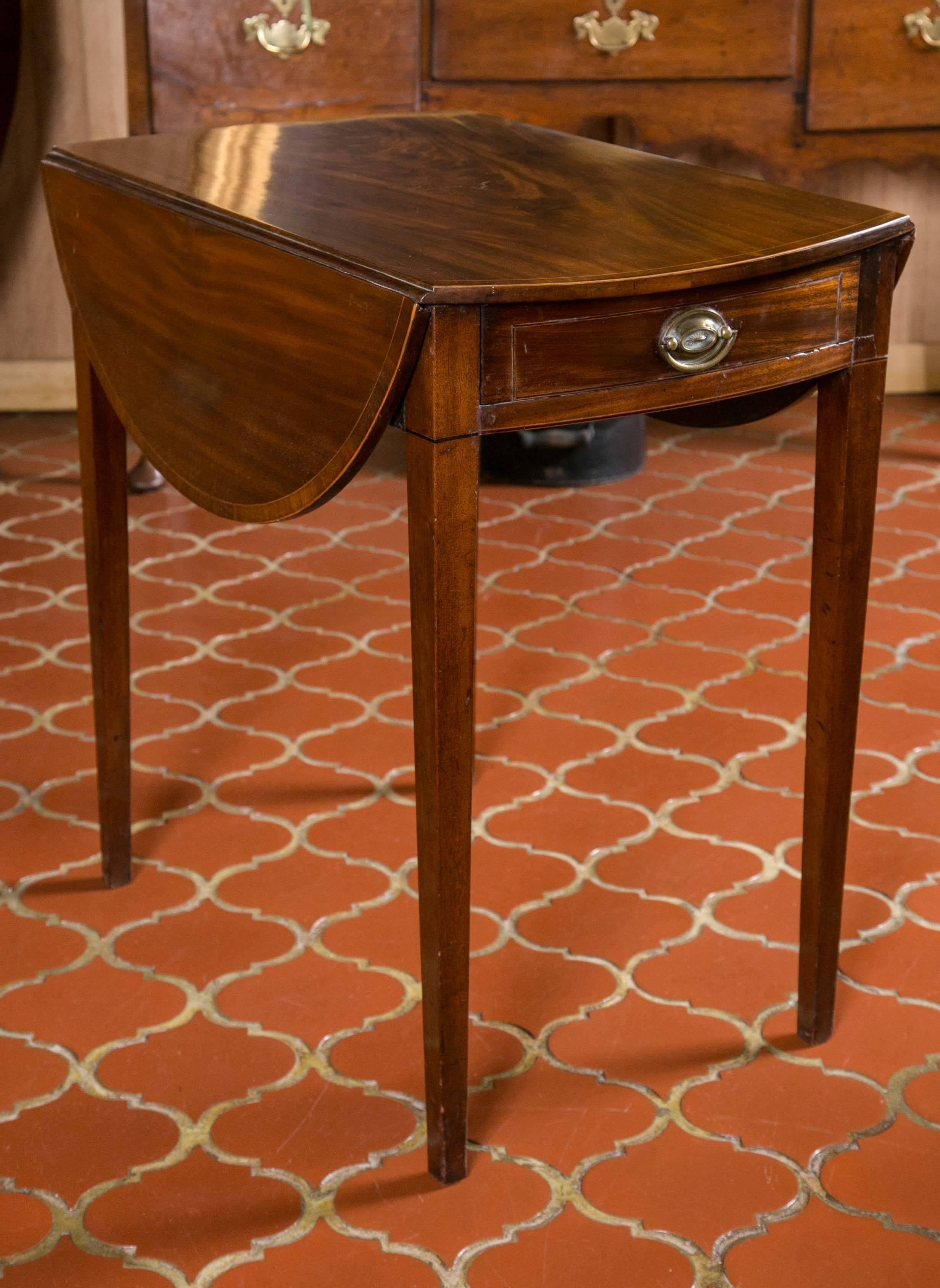 Georgian period mahogany and crossbanded Pembroke table. Crossbanded and string inlaid top and rounded twin flaps above a single drawer with crossbanding and inlay supported by square tapered legs. Each flap is 8.75 in.