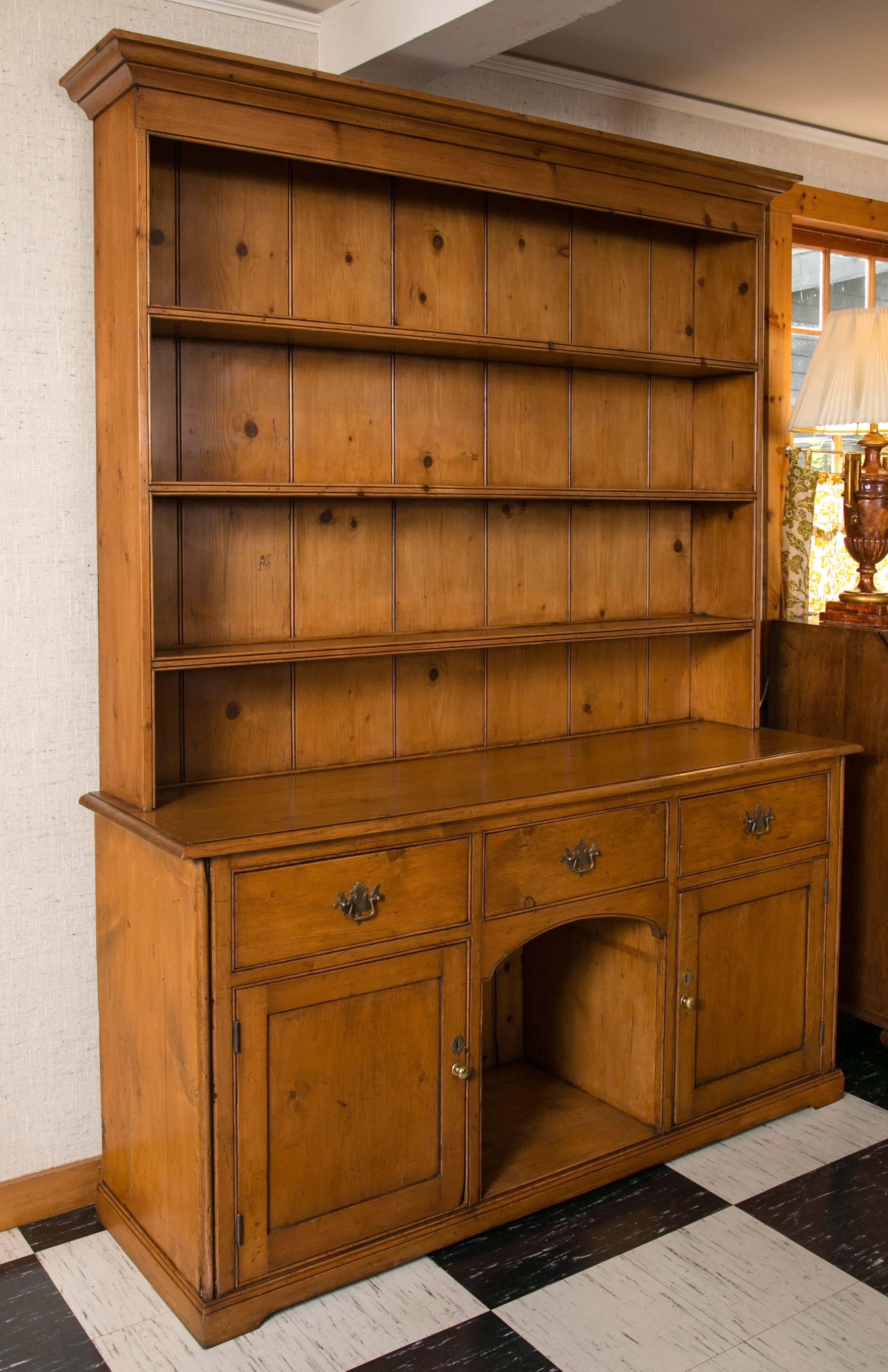 Yorkshire pine dresser with three drawers over a central kennel opening flanked by two storage cabinets. Top section features three fixed shelves. In excellent condition with warm patina and original back boards.