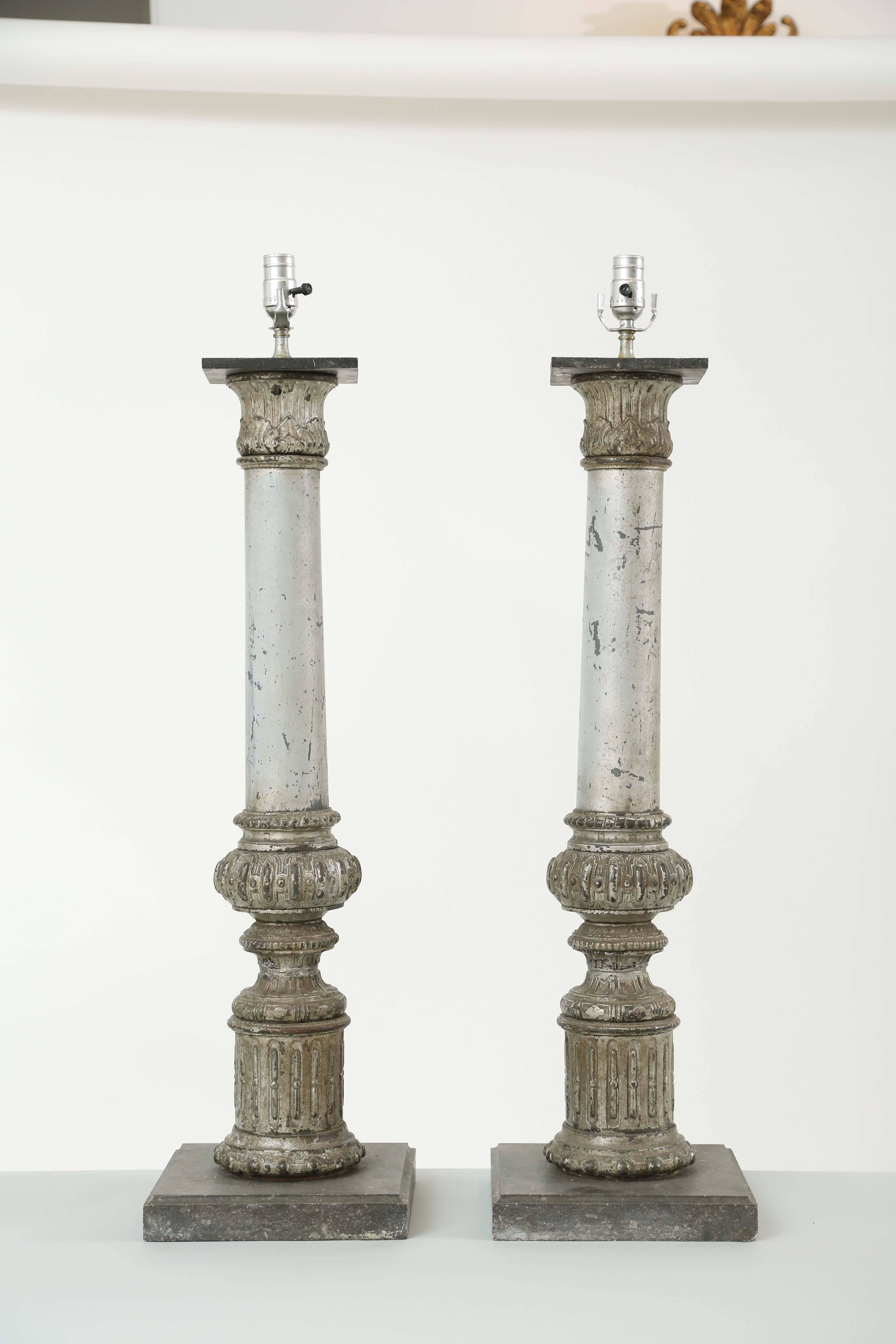 Paire de lampes, en fer argenté peint et parcellaire, chacune une colonne avec un chapiteau corinthien, sur une base tronconique et une plinthe cylindrique cannelée, montées sur des plateformes en marbre.

Stock ID : D9377