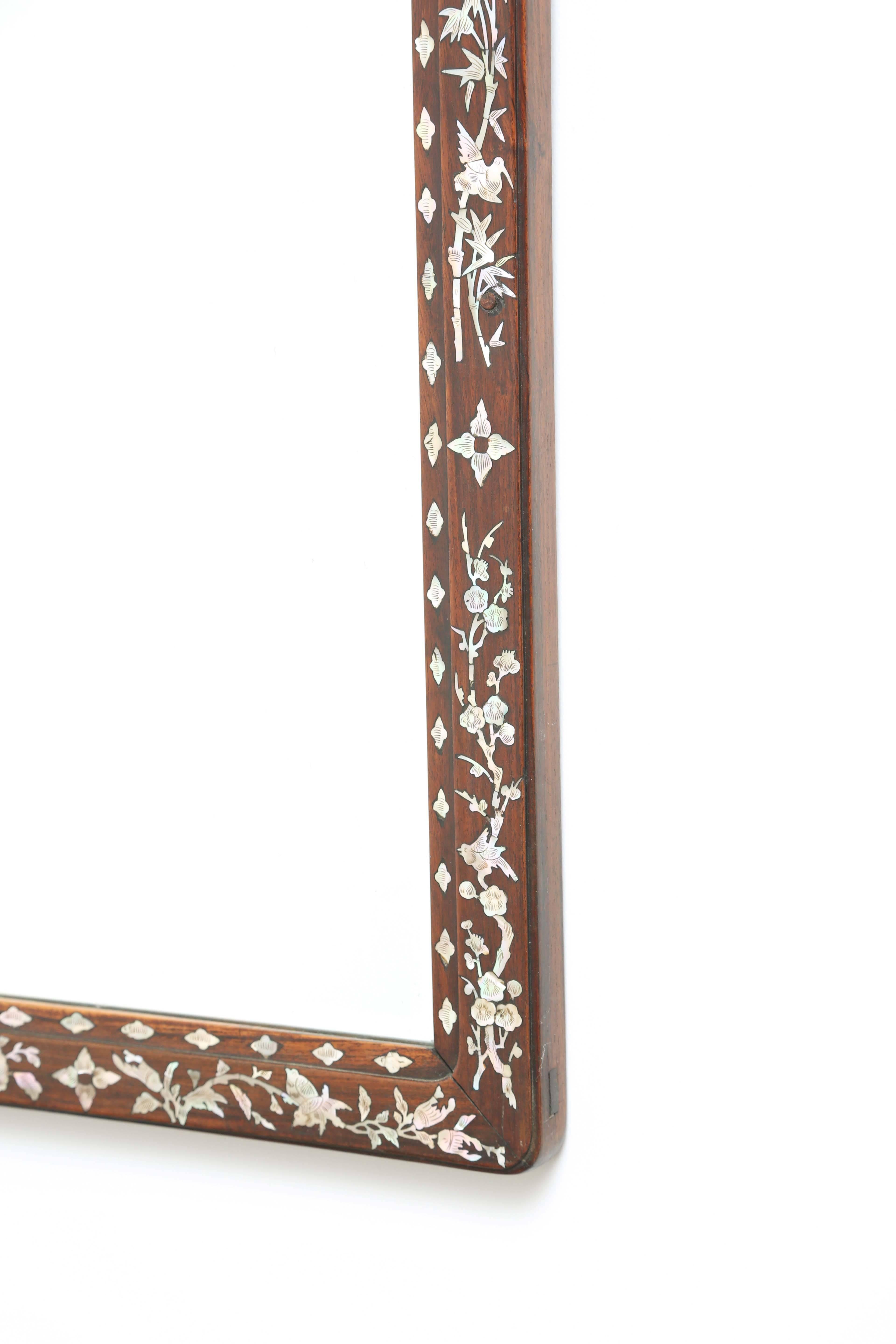 Rectangular mirror, having a frame of rosewood, inlaid with mother-of-pearl in delicate pattern of bamboo and birds, framed with elongated quatrefoils and stars.

Stock ID: D2200