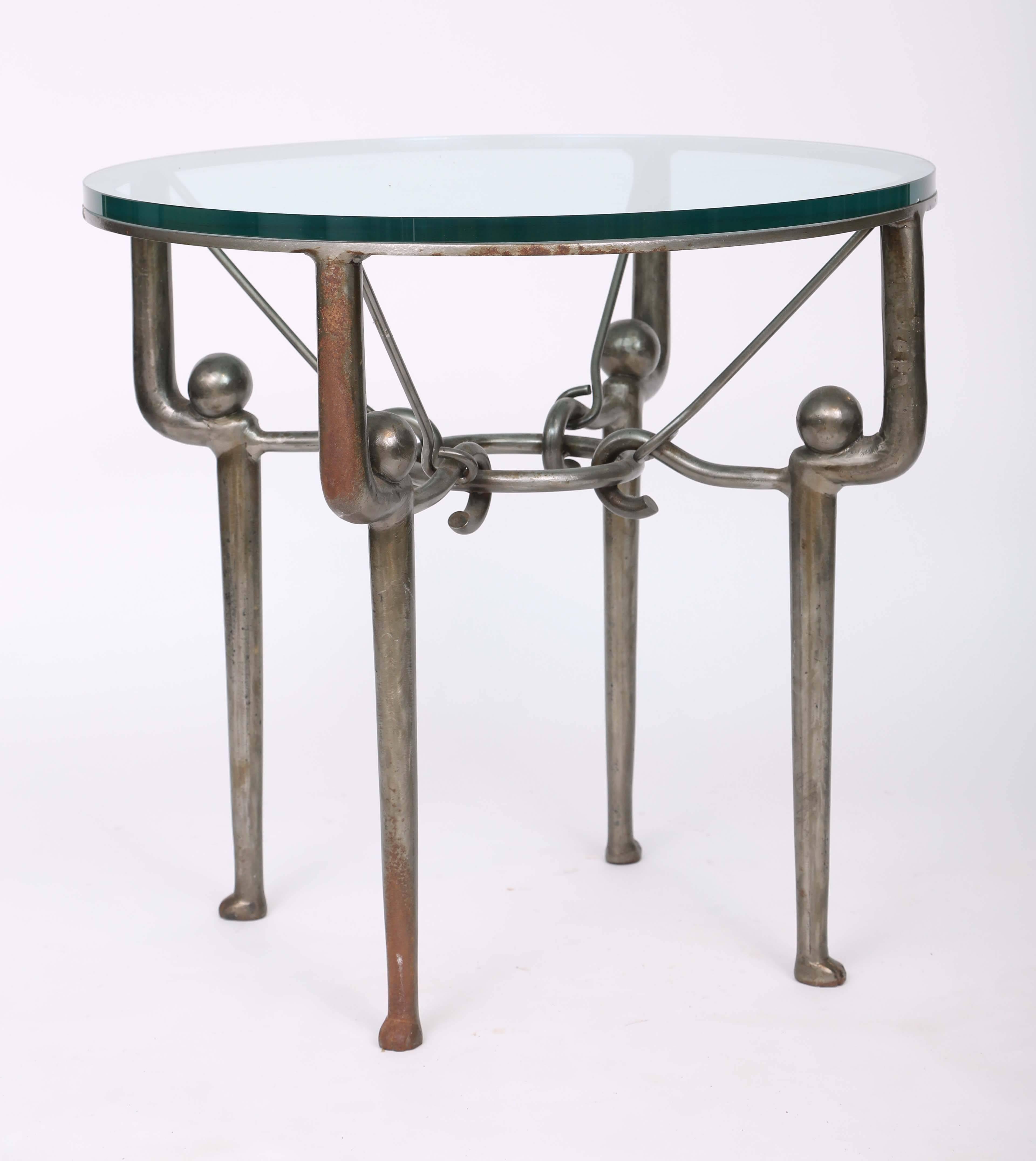 Pair of end tables, each having a round glass top, on heavy iron base with a finish of oxidized pewter-toned metal, raised on four hock-legs with ball finials, joined by hook stretchers. 

Stock ID: D6764.