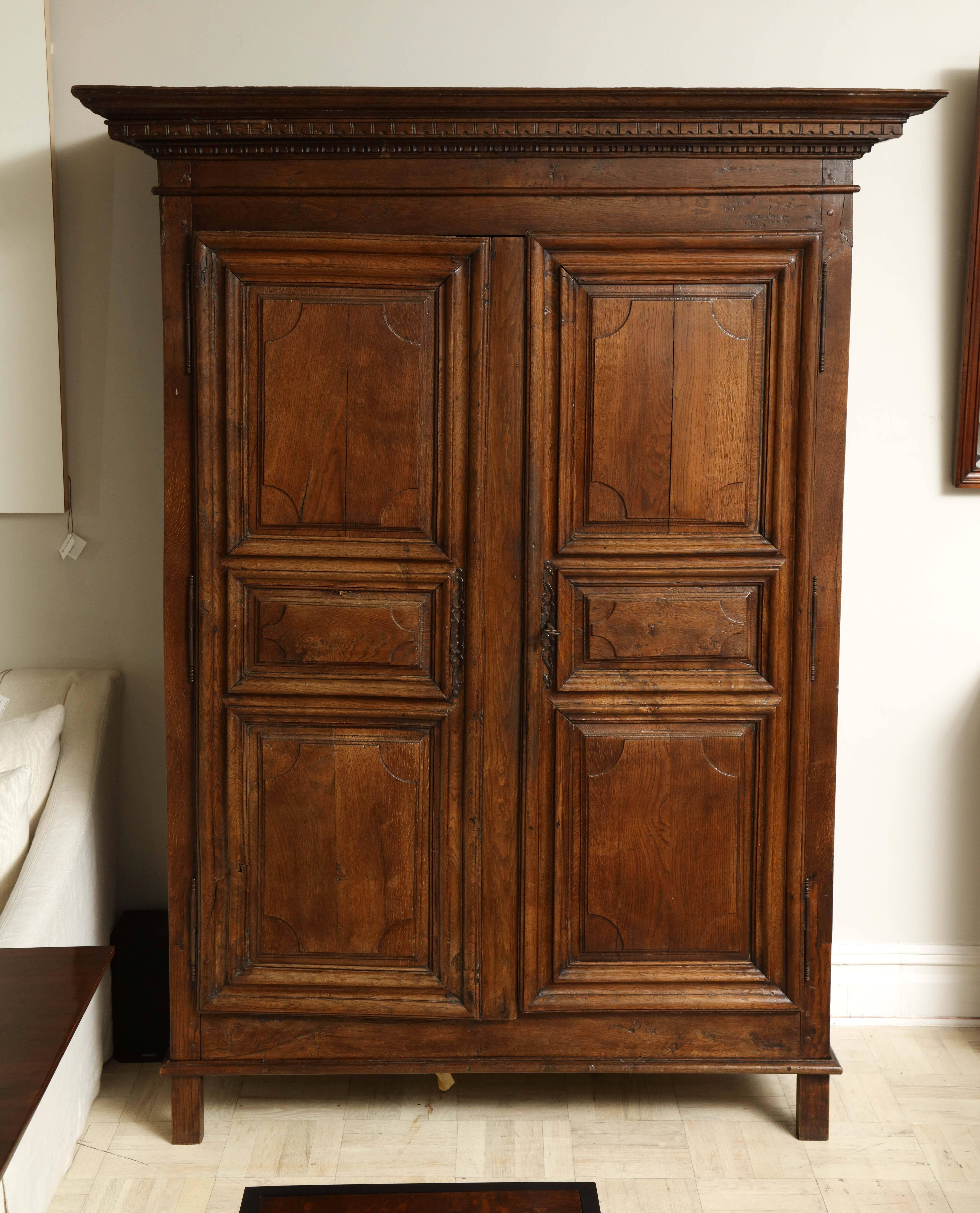 Late 18th century oak armoire, two doors, stepped cornice, square legs.