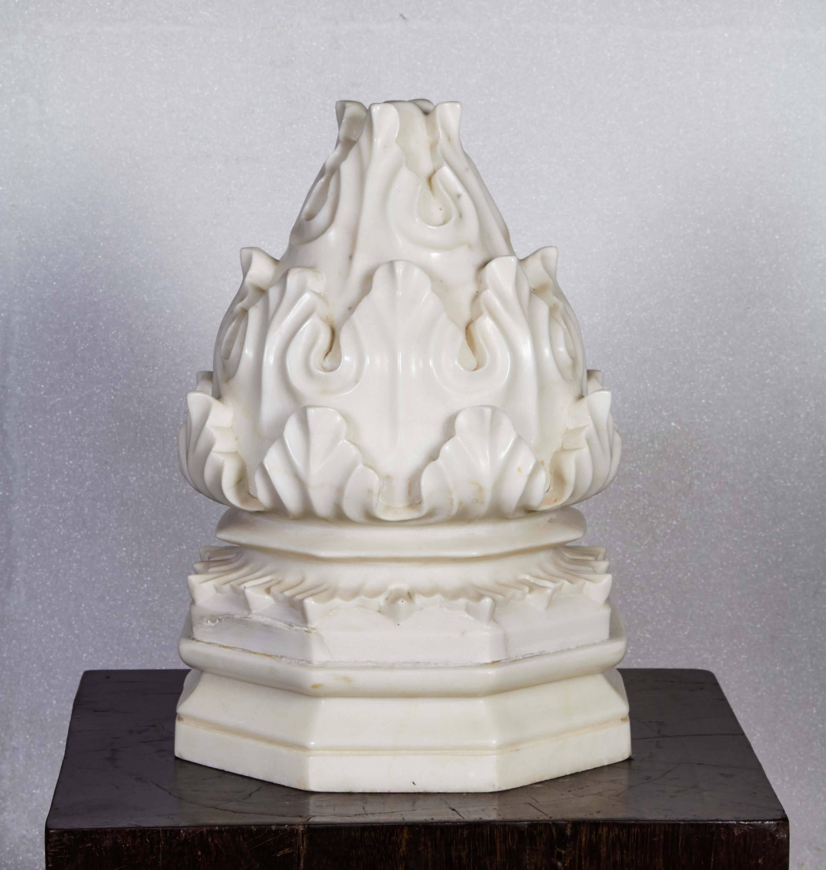 A large carved white marble carpet weight from India, with a traditional flame carving on an octagonal base. For the table, shelf or floor. Also makes a singular decorative element for patios, gardens or decks. 