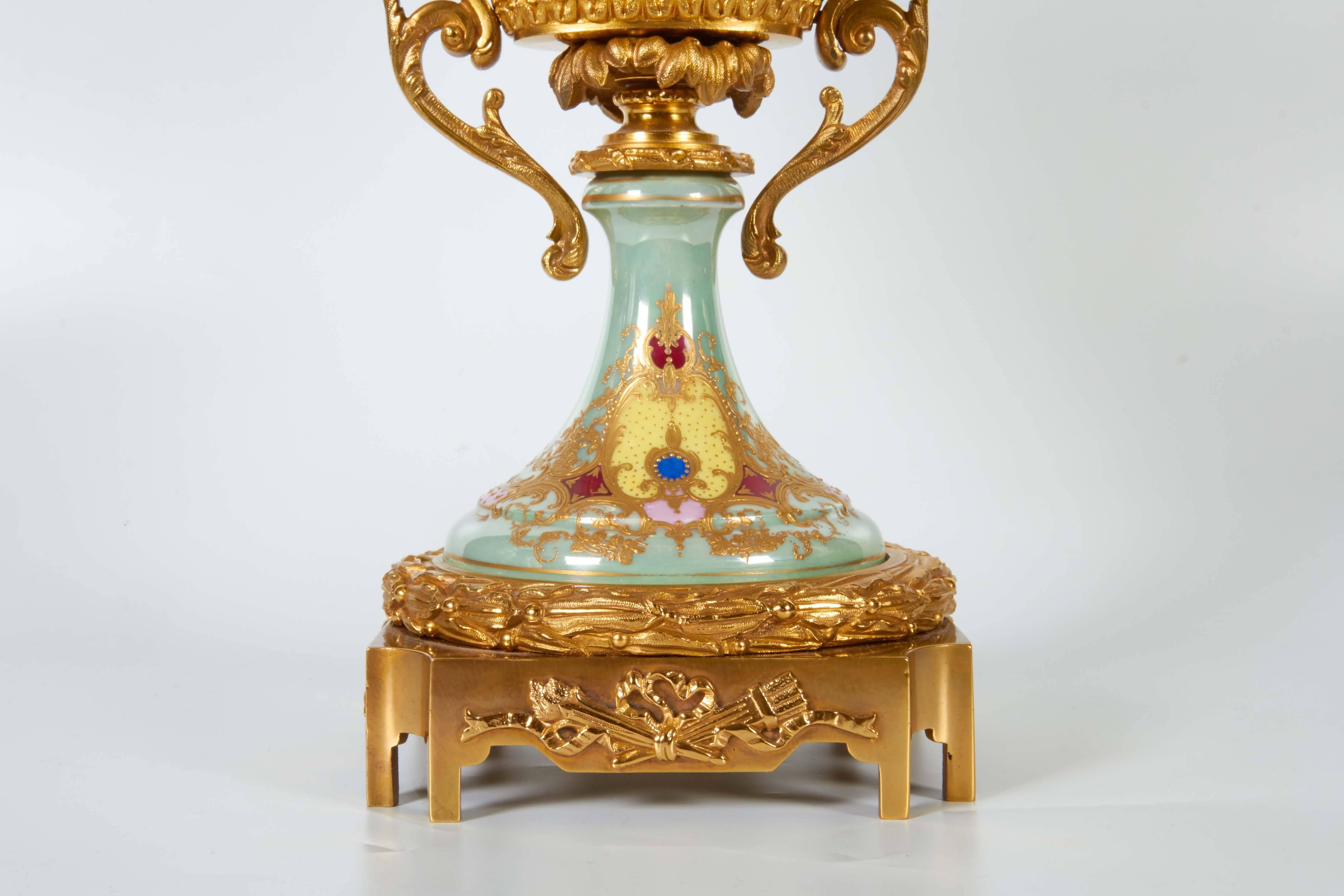 An unusual antique French iridescent Sèvres Porcelain and ormolu-mounted oval shaped centerpiece, the light jade green iridescent color Sèvres Porcelain painted with a beautiful scene of a beauty amidst cupids with flowers and butterflies, the