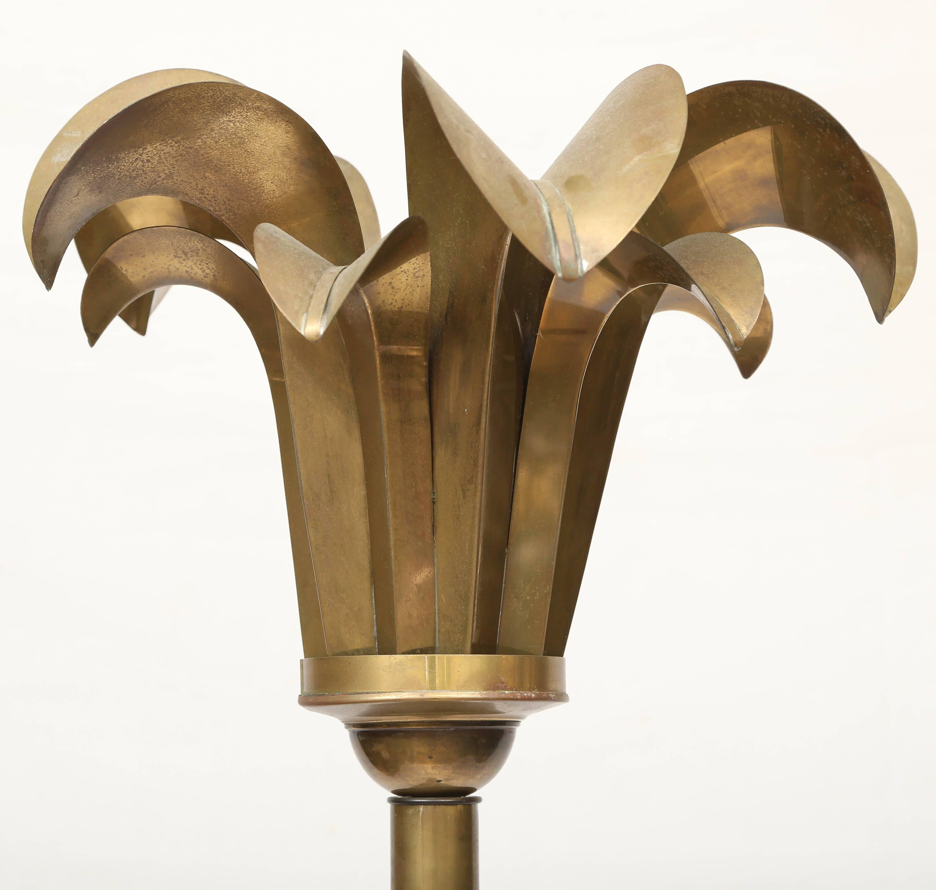 Pair of Art Deco floor lamps in brass. Heavy patina. Torchiere in palm leaf motif fitting for Miami where they were used in a lounge at the Miami International airport during the days before the Jet set.