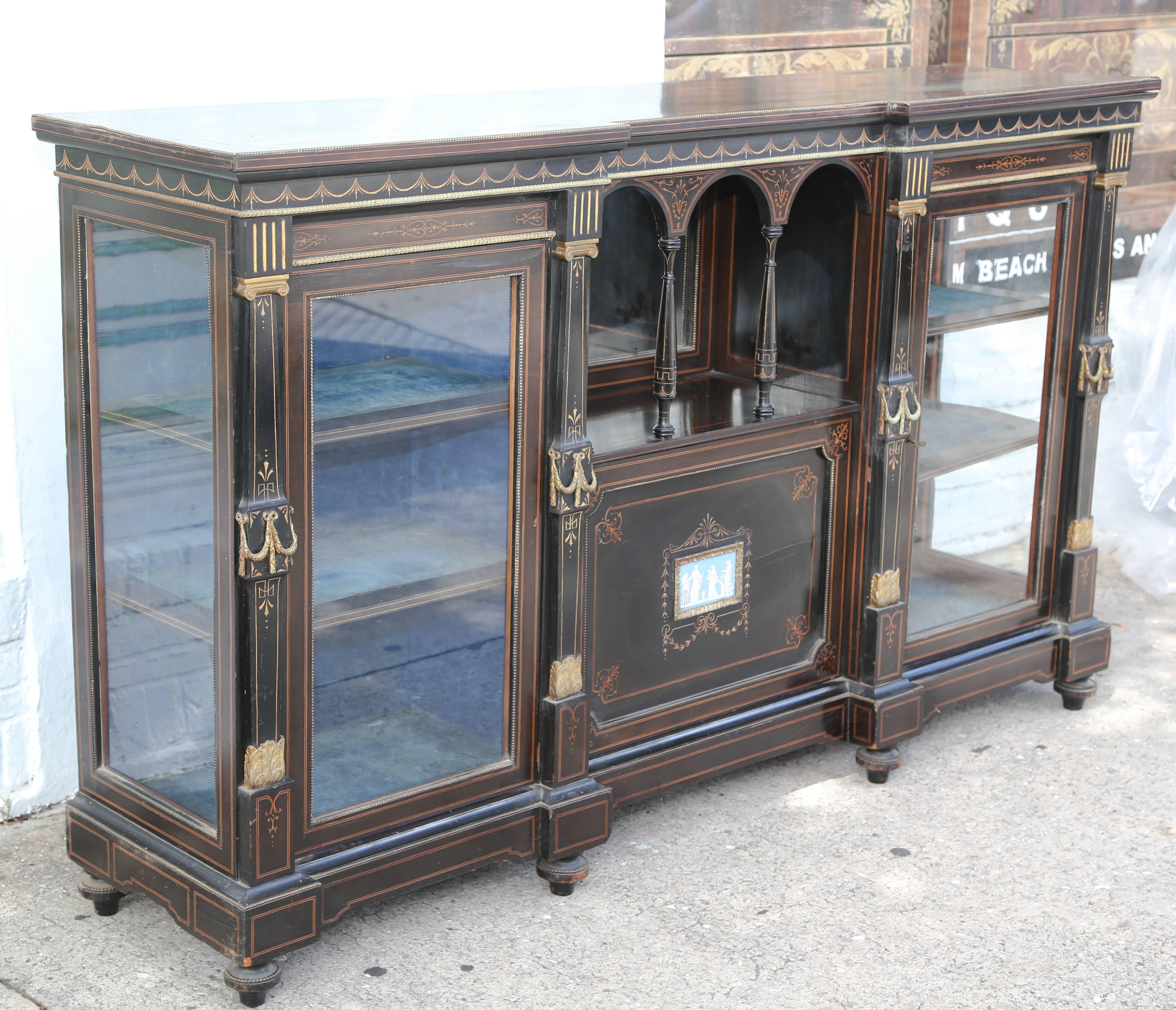This is a superb quality credenza could have many uses server, cabinet etc.
Its ebony with brass work satinwood inlay also having a Wedge wood plaque to the center door.
Round the top there are swags and tails, also to the top there is satinwood