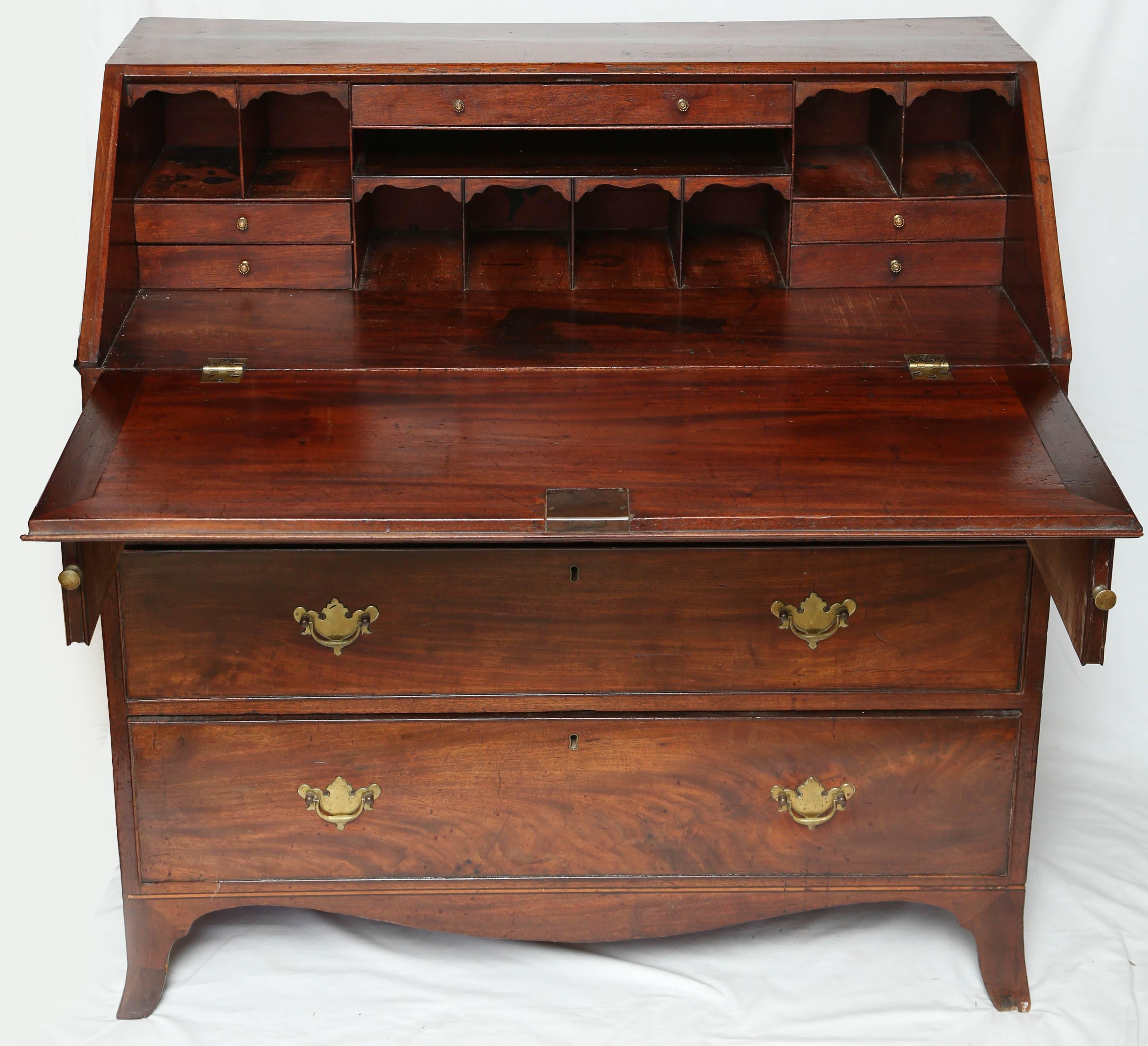 This is a very nice early Georgian bureau circa 1860 made in England. It sits on bracket feet, either side are pulls to support the flap. All the drawer lining are solid oak with dovetail joints. Inside its fitted with drawers and letter