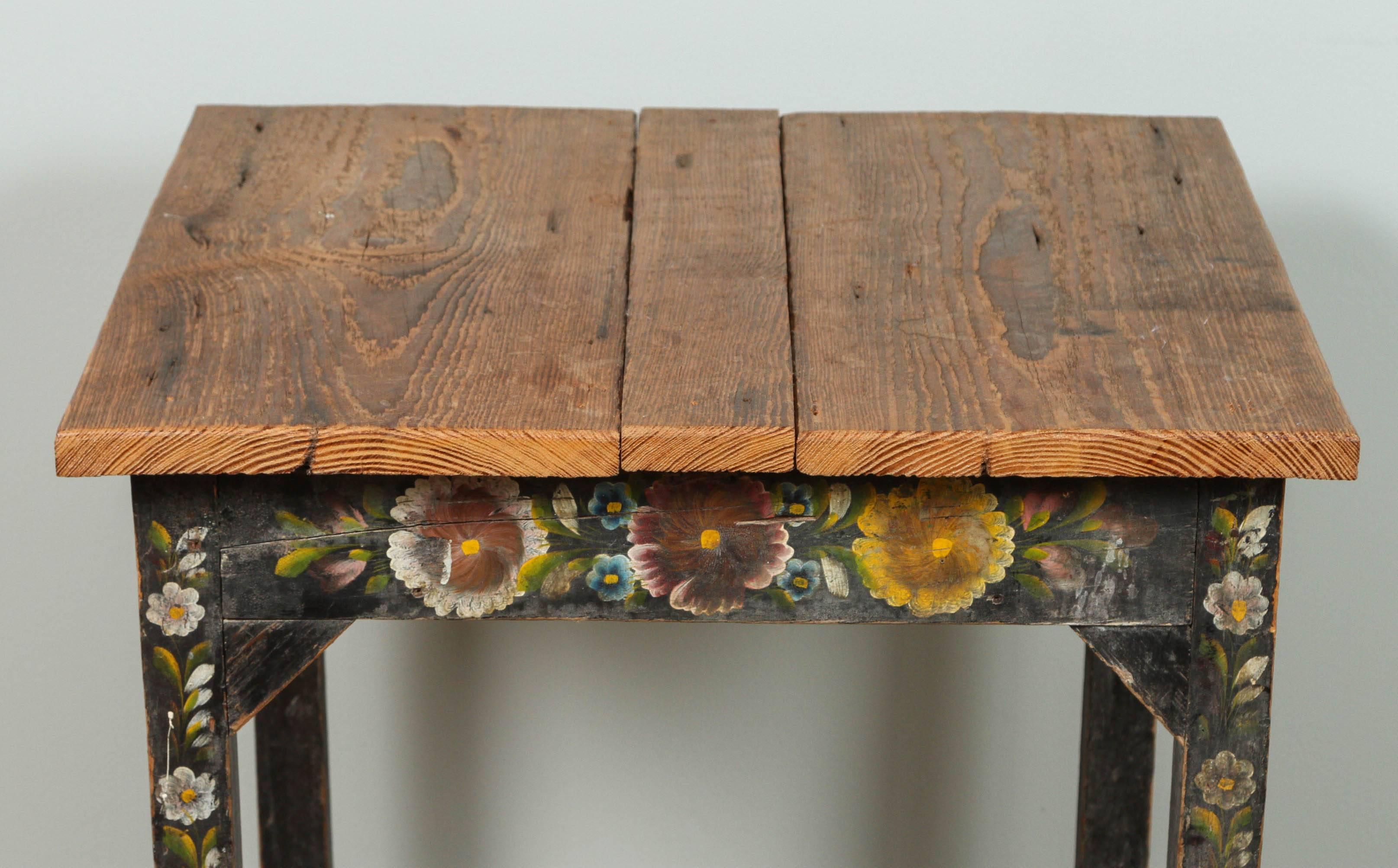 Vintage table with Classic Mexican floral designs from Olinala in state of Guerrero. Wear to the paint especially on the legs. Raw wood table top and painted base with yellow, red and blue flowers.