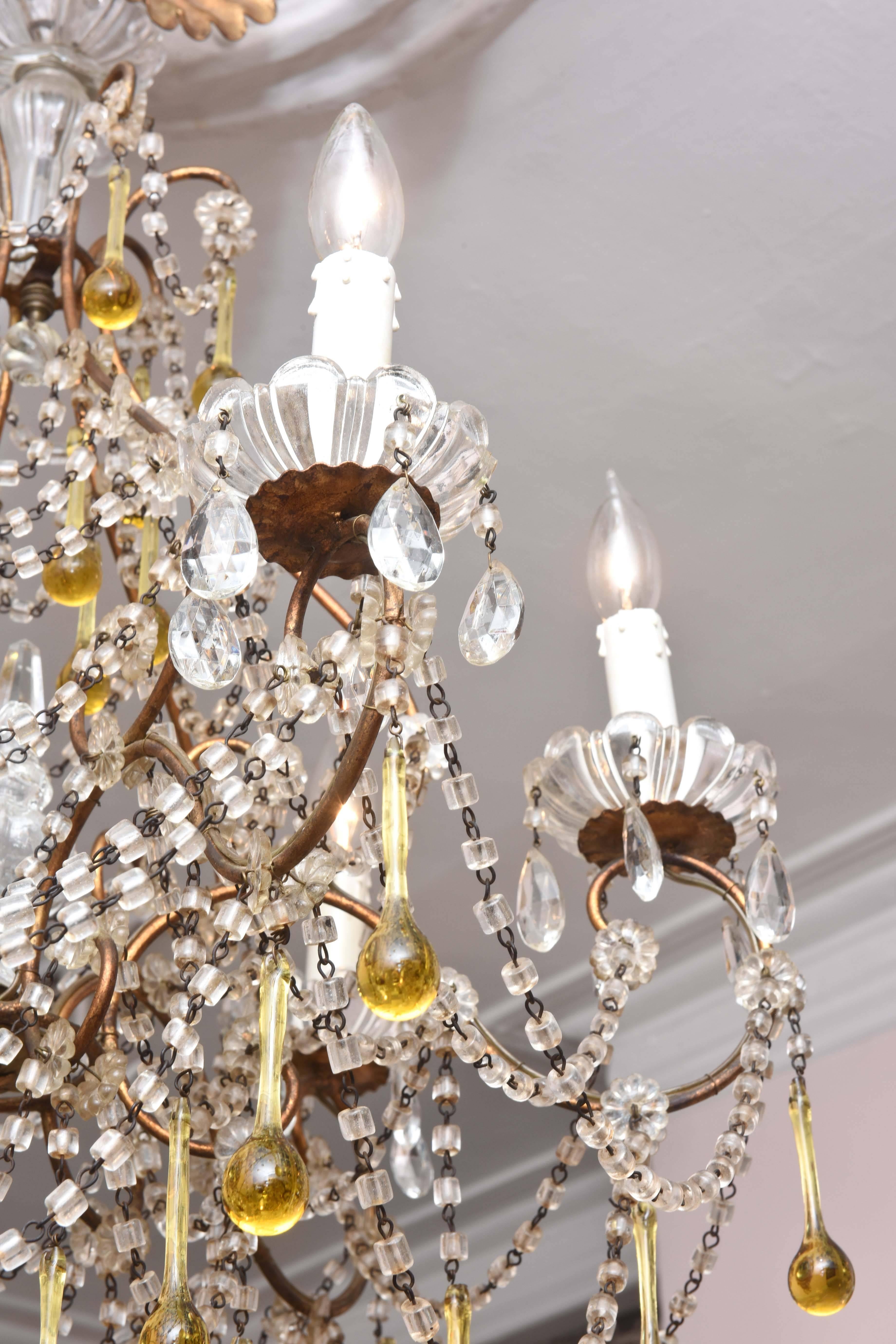 A charming blown glass bead swag chandelier with amber colored drops. Retaining its all original glass pieces and we do not see any florettes missing. Beautifully proportioned and as you can see in working order. Nice patina to the gilt metal and