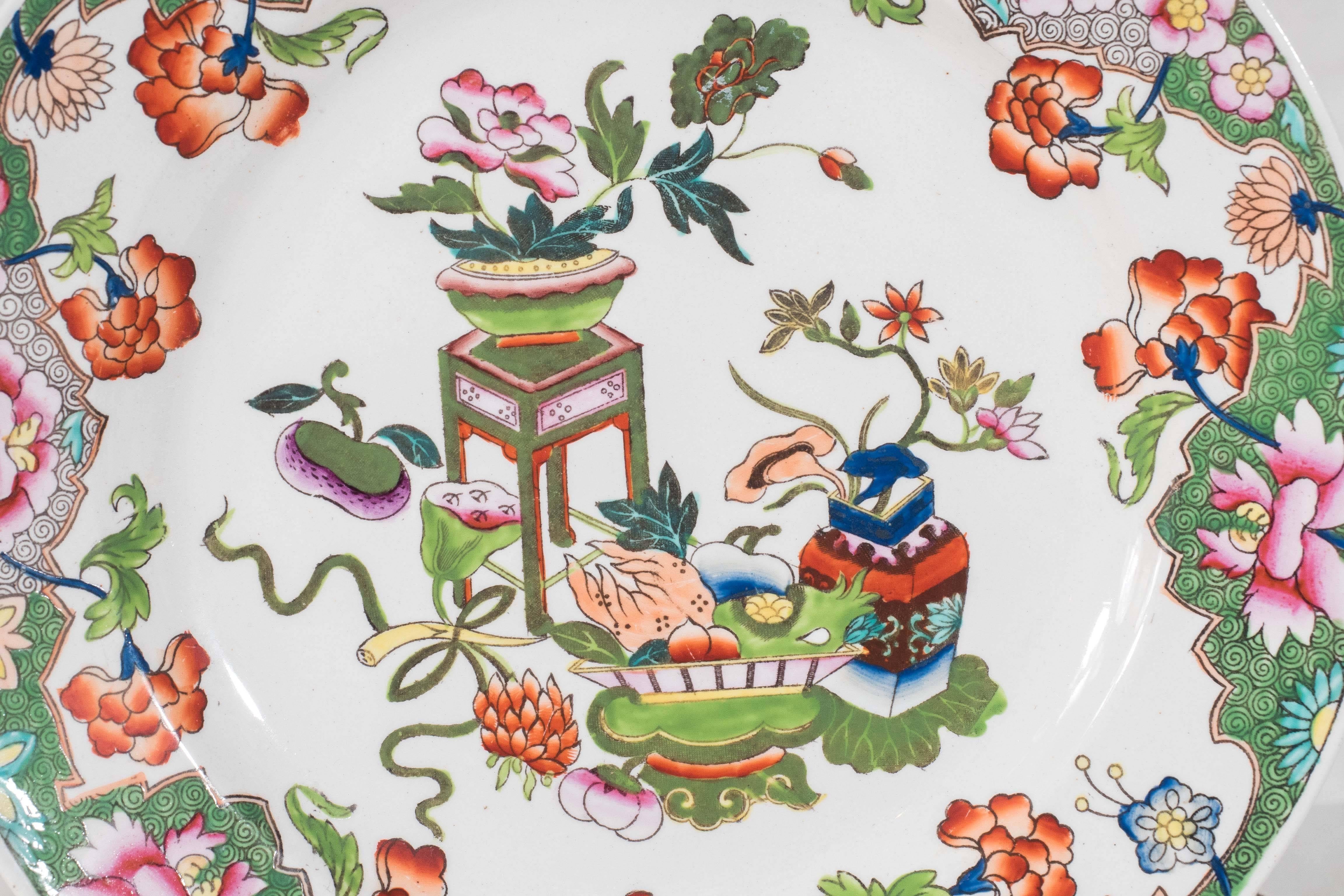 We are pleased to offer this set of brightly colored Spode dessert dishes decorated with the objects of good luck and a floral border. Painted in bright enamels of greens, pinks, orange and yellow on a bright white ground. 
The bright colors against