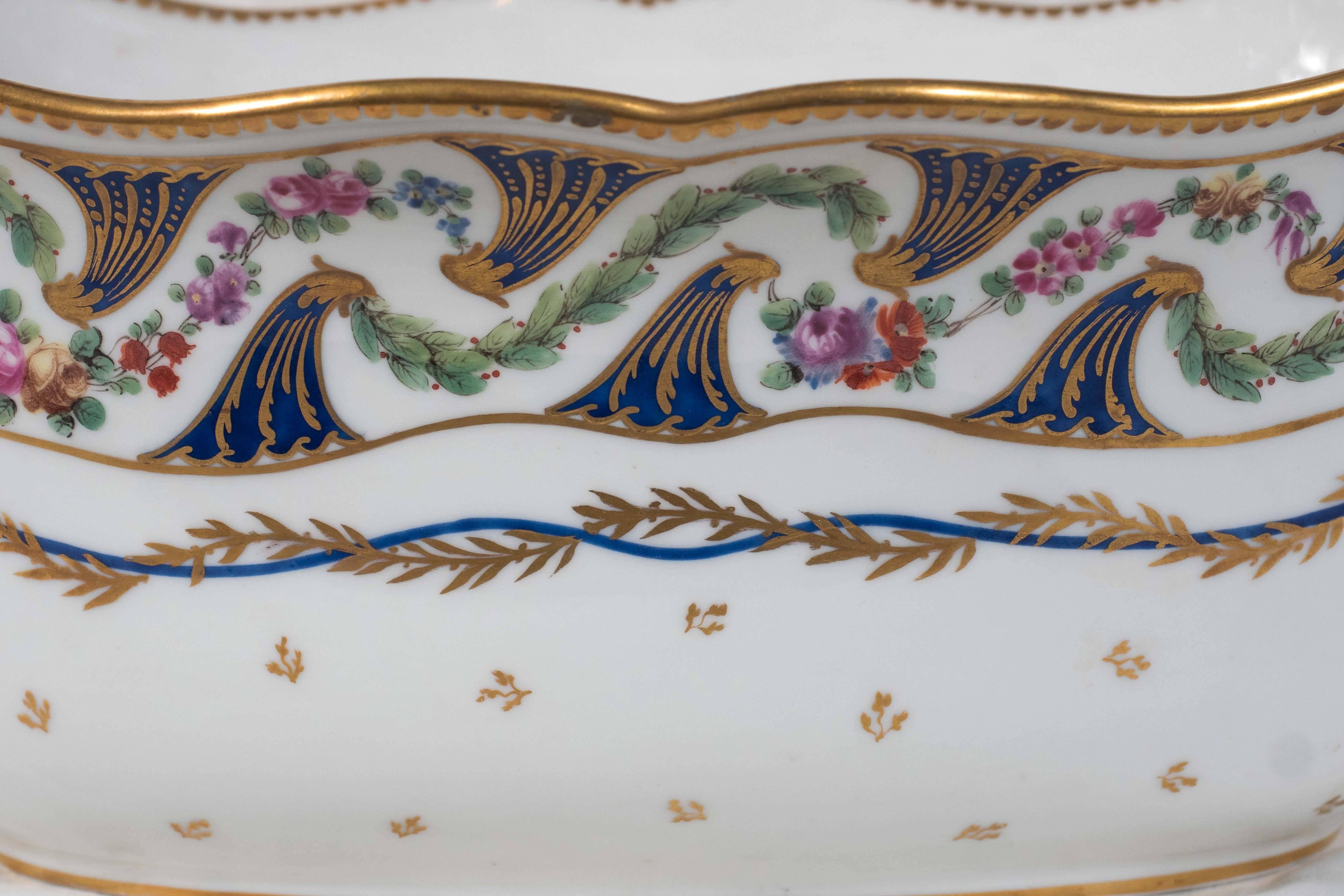 Antique French planter in the Sevres style hand-painted with small pink roses in a cresting wave pattern. 
This oval shaped planter was originally used in the 19th century as a wine cooler. 
But today, it would be placed either in the center of a