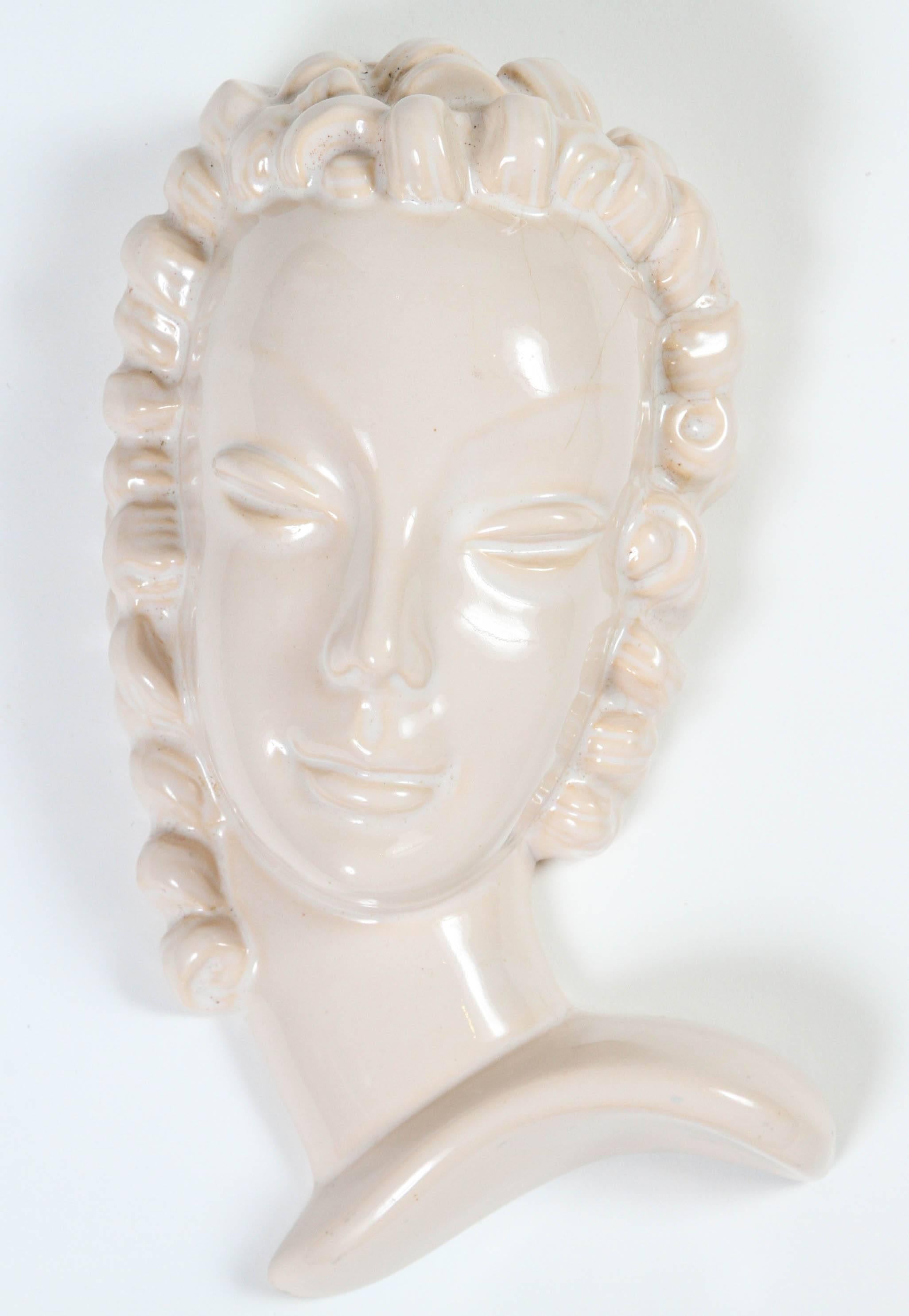 Art Deco wall hanging bust of woman with curly hair. White glazed pottery.
  