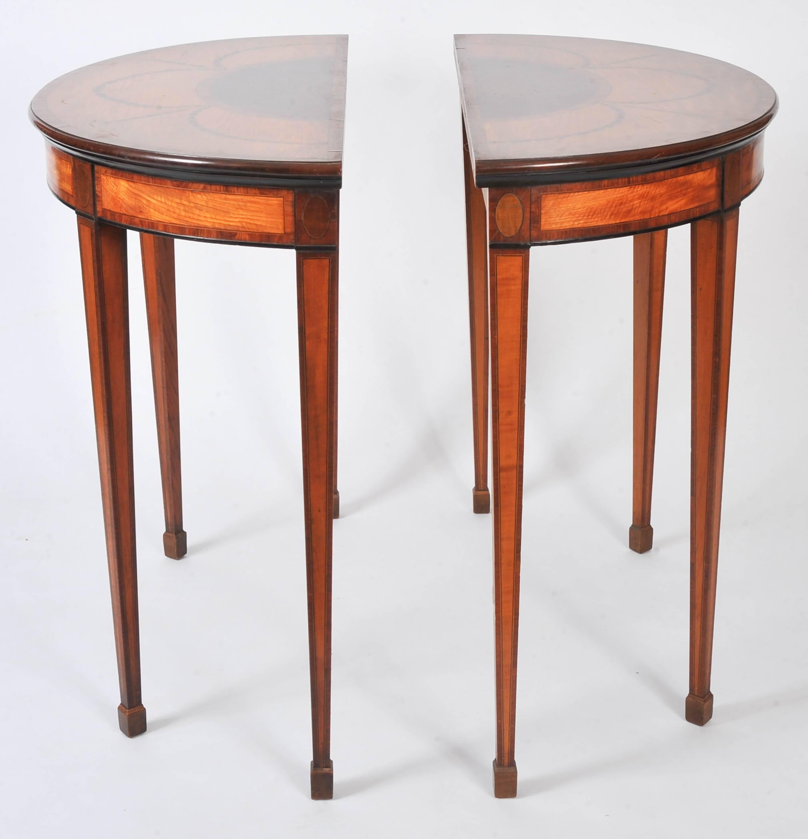 This charming pair of semi-elliptical side tables features 18th century satinwood tops, inlaid with swags and festoons in the classical manner. The tops are crossbanded with rosewood and hare wood inset and detailing. They are supported on four