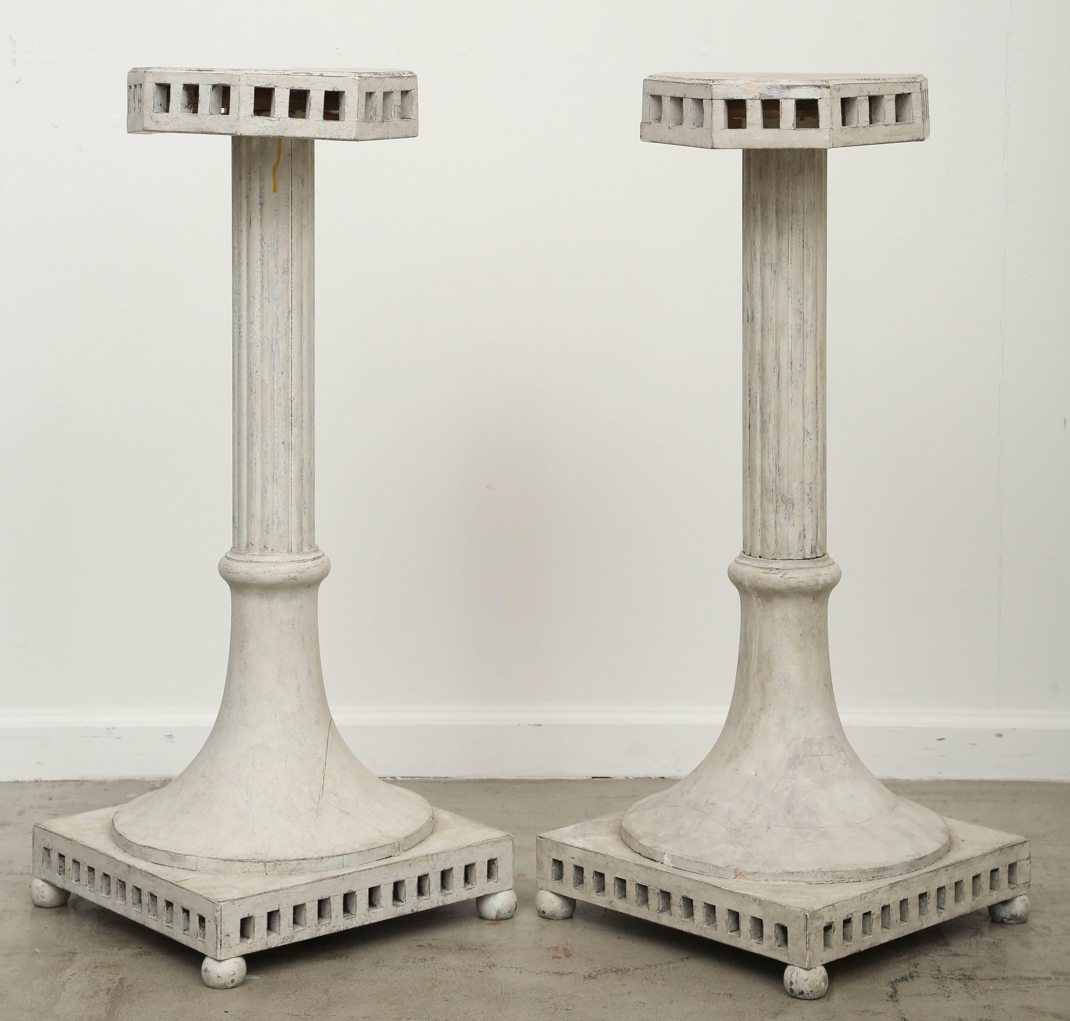 Pair of antique Swedish Gustavian style painted pedestals, mid-19th century.
Tops are octagonal shape with a cut-out apron, mounted on a fluted pedestal and flared out lower portion onto a square base with a cut-out lower border, on four small bun