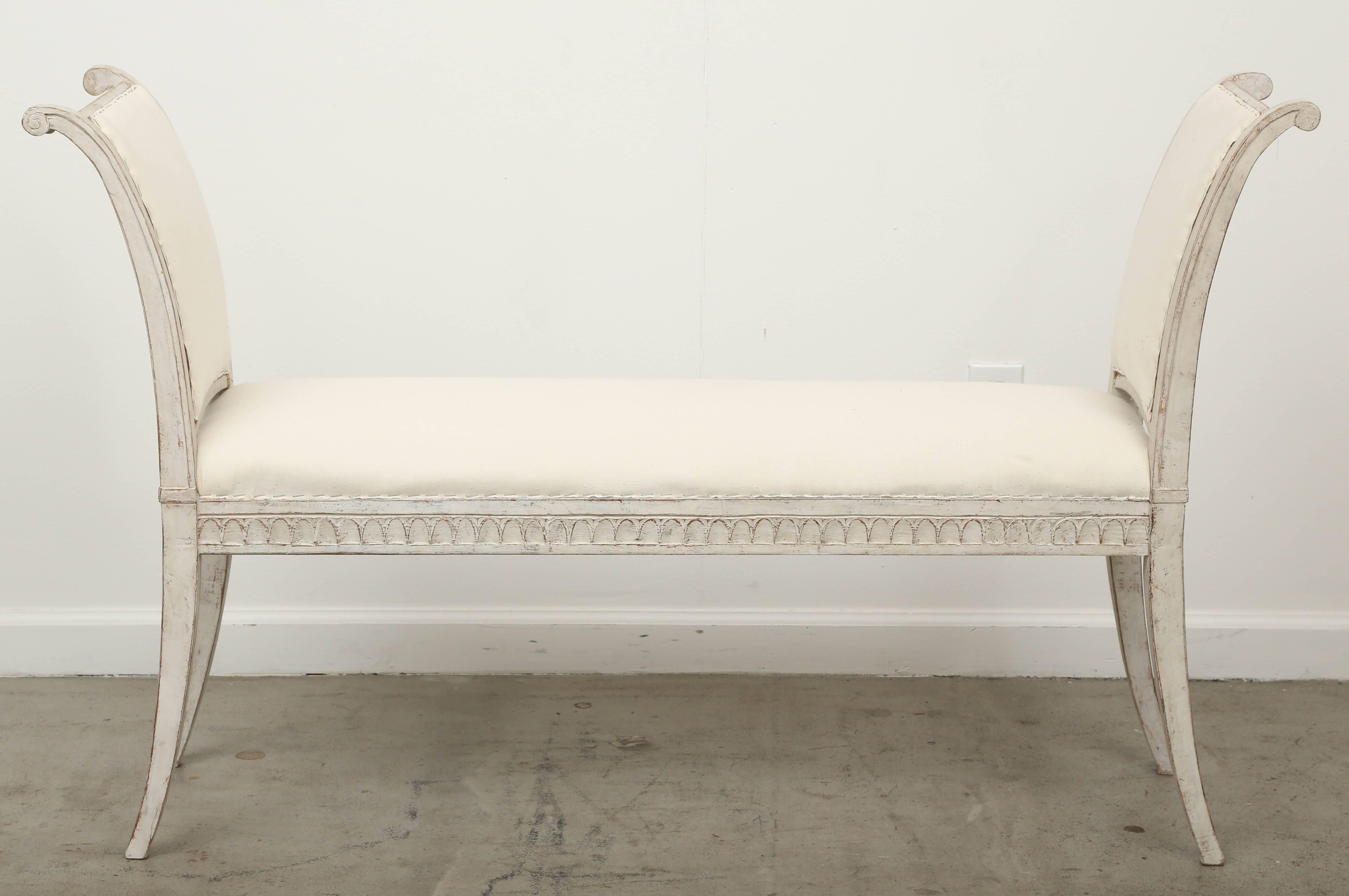 Pair of antique Swedish Gustavian benches with curved arms, mid-19th century.
Very graceful long benches with arched carved arms, lambs tongue border around base of upholstery, square curved, tapered legs. Swedish distressed matte gray-white paint
