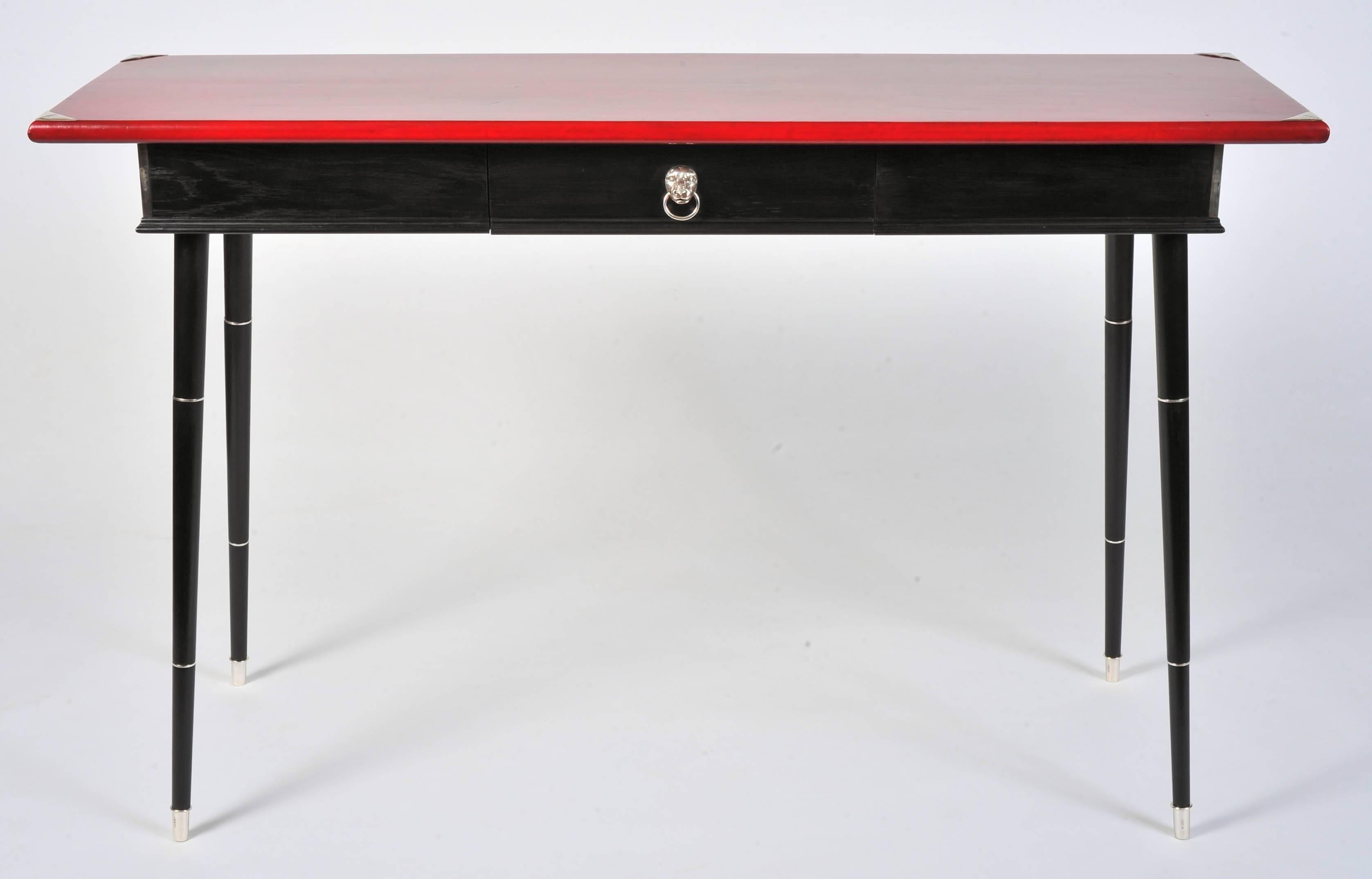 A beautifully designed custom-made console table; the polished red leather top over ebonized oak carcass with single drawer standing on turned tapering beech legs; with solid hallmarked silver mounts throughout, comprising applied corners to the