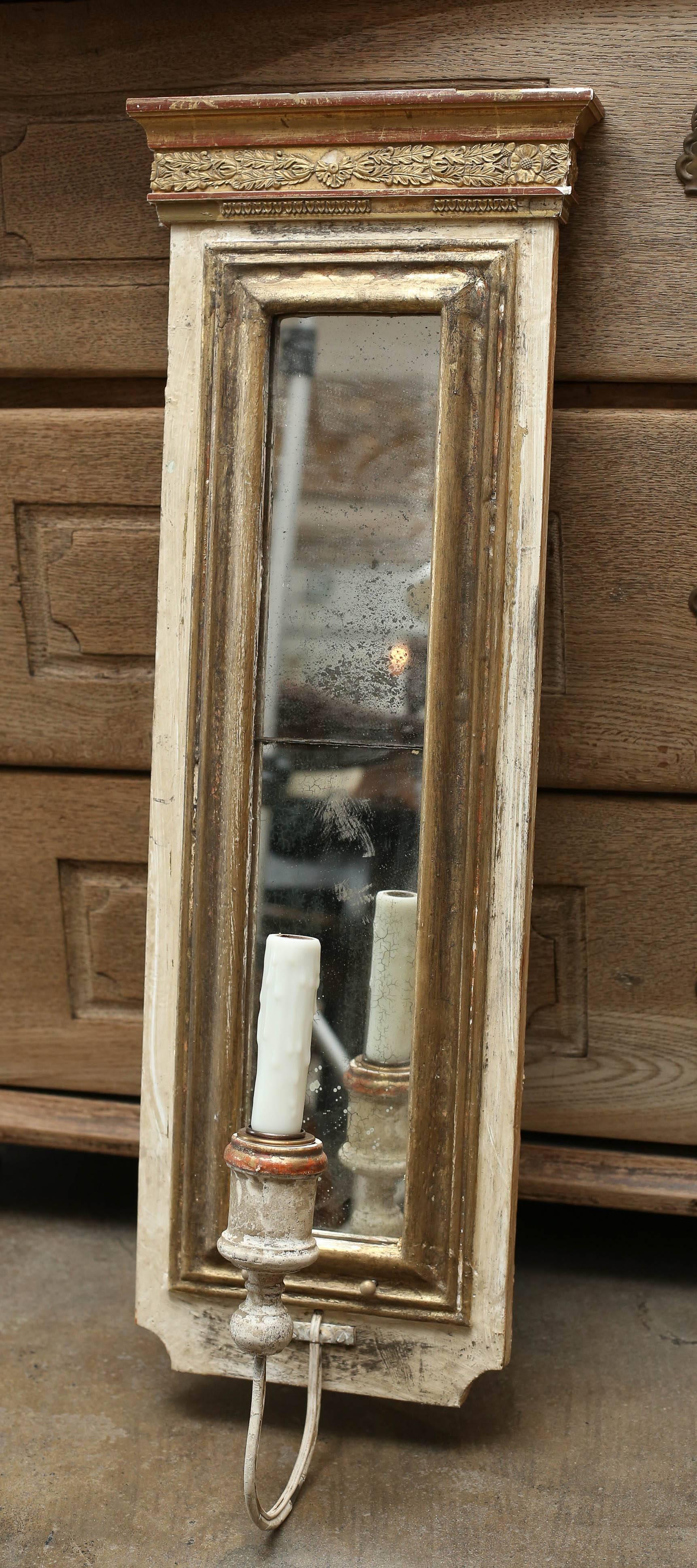 Sconces made from 18th century gilt fragments and antique mercury mirror. Sconces have been wired for use in the United States. Wax candle sleeves.