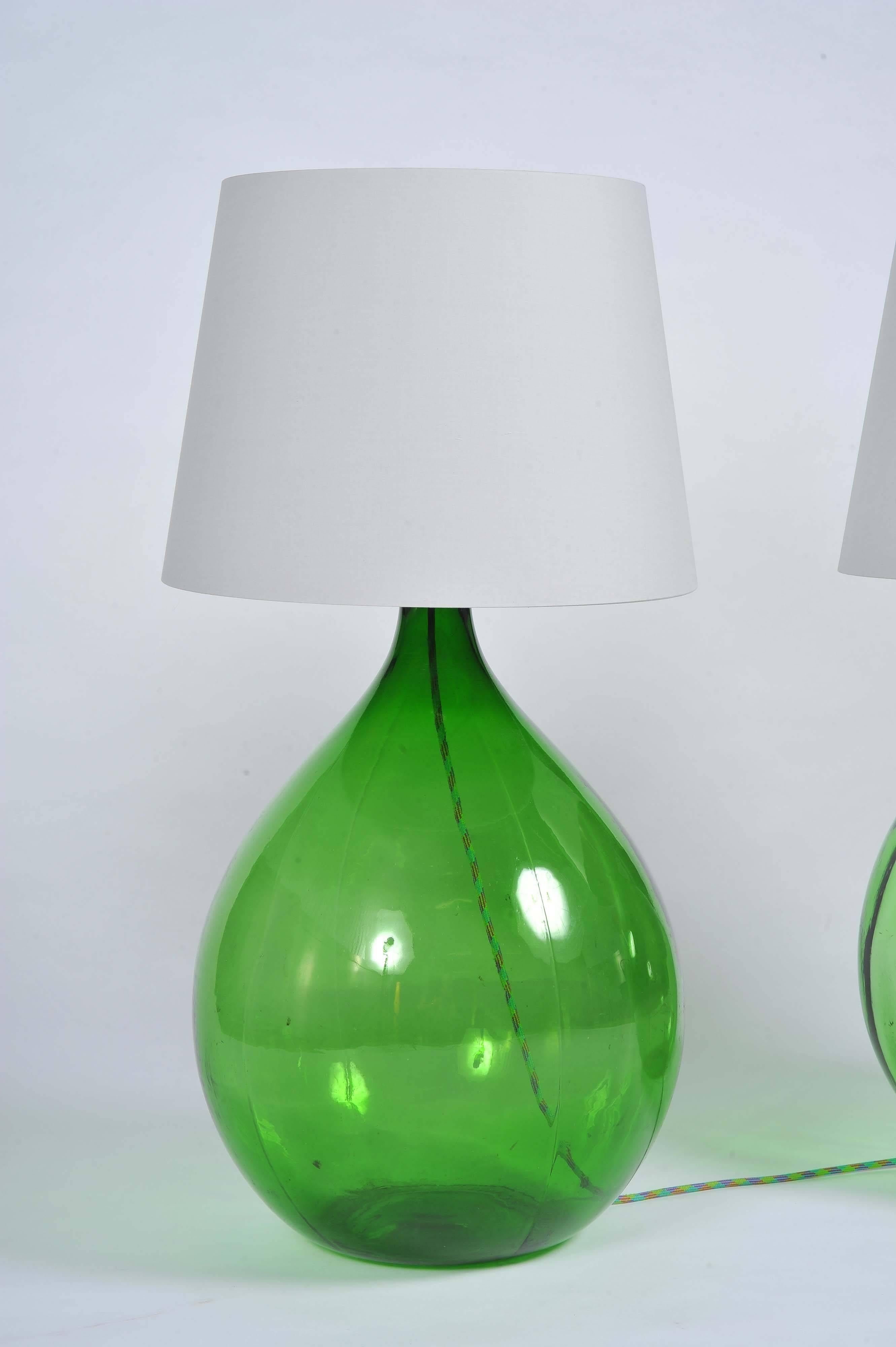 A pair of vintage Bohemian/rustic style green Demijohn glass bottles. They are handmade pieces, that have been redesigned to be fit as table lamps or floor lamps. 

Disclaimer the lamp would be sold without the shades.

Made by Joelle Talmasse.
