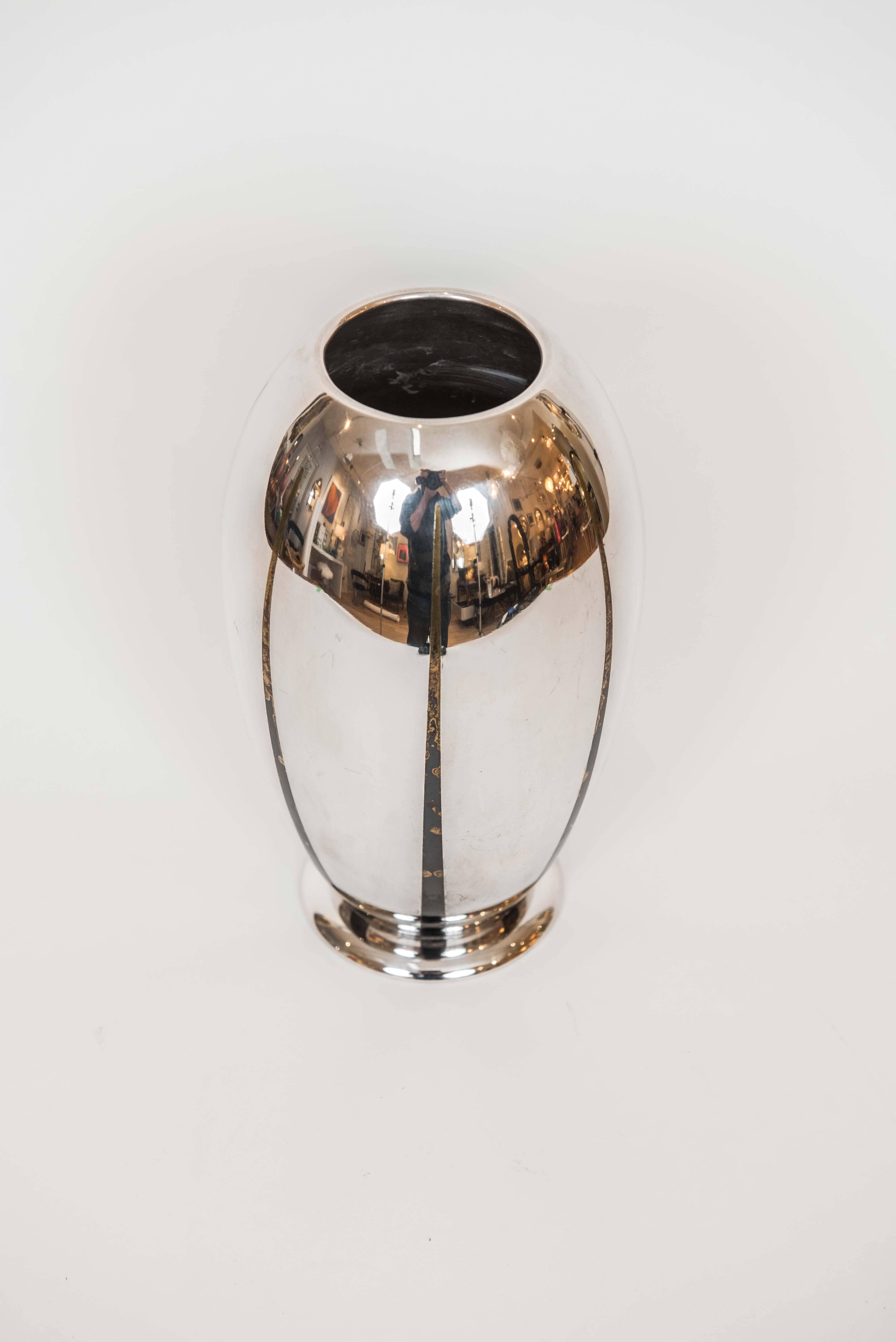 This gleaming Art Deco vase in silver plate is accented with distressed bronze
highlights and is in excellent vintage condition. There are no dents or dings and
the 
