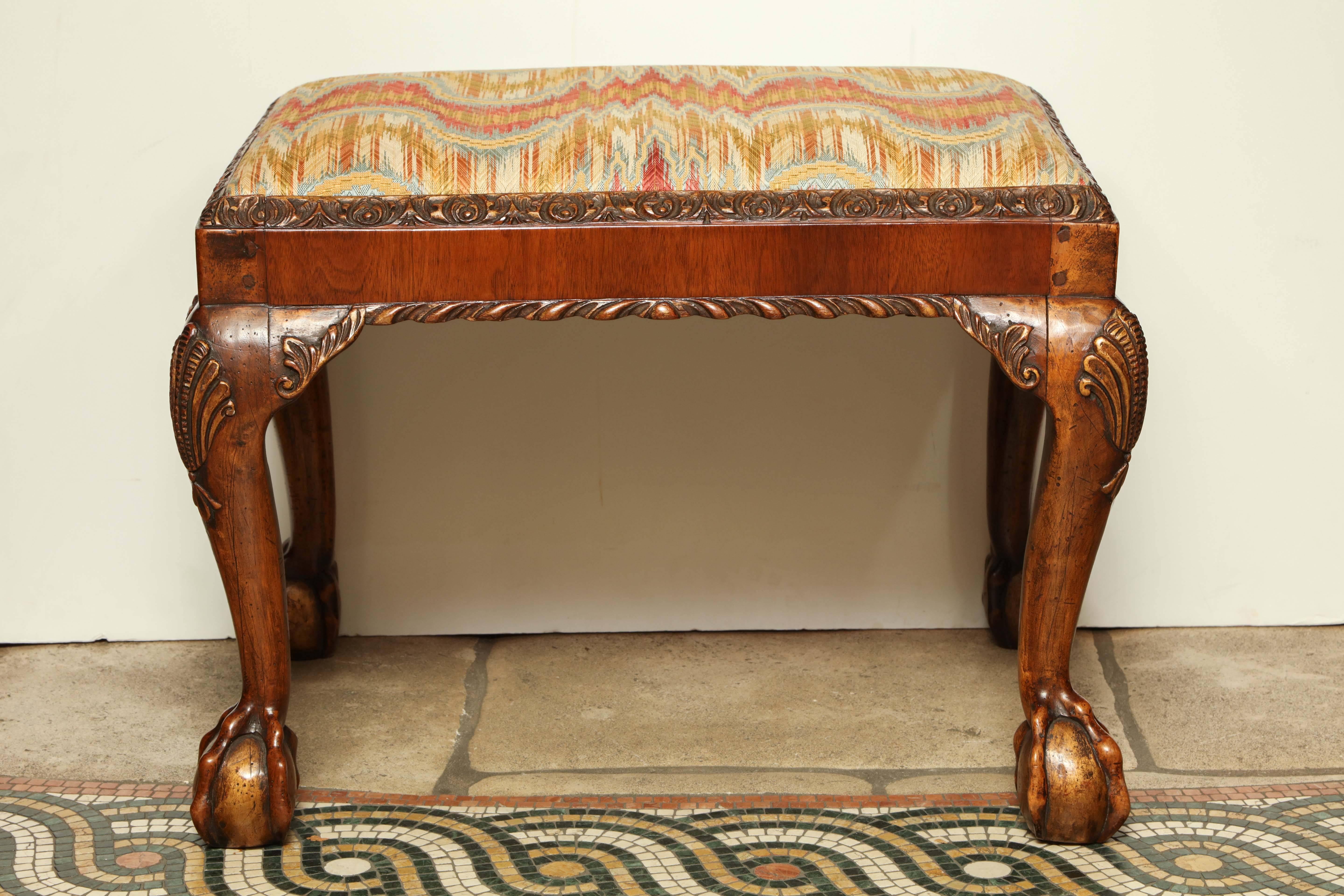 A fine pair of George II carved mahogany ball and claw foot stool with carved gadrooned edges and shell carved knees.