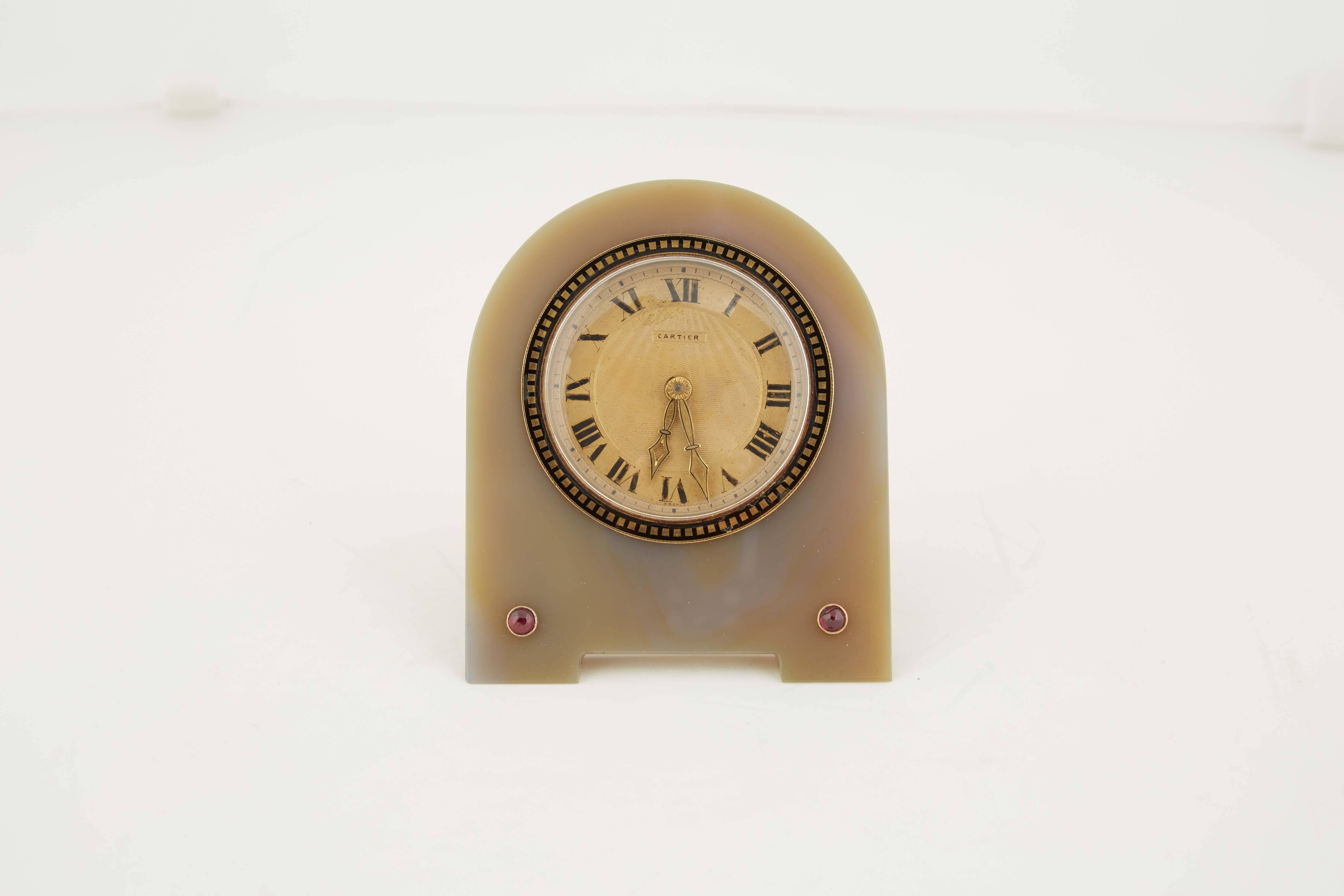 A very fine Cartier Art Deco enamel agate desk clock with rubies, movement by European Watch & Clock Co.

Numbered 1913 on the back of the easel.

Please ask for more photos if needed.