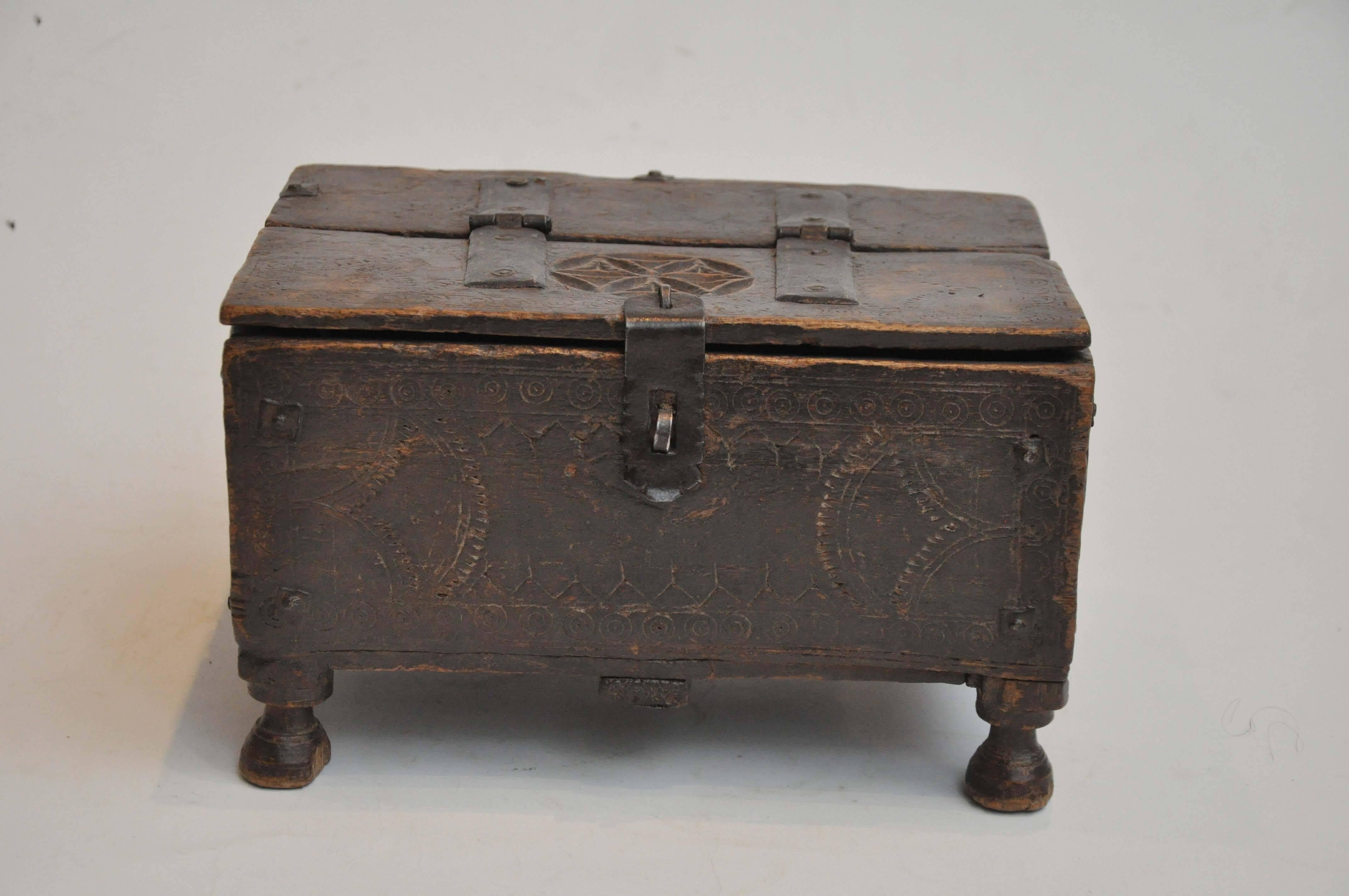 Late 19th century Moroccan footed box. Found in Paris. Hand-carved wooden details with metal hinges and latch. Interior is upholstered. Likely a keepsake box. 

Dimensions: 6.75